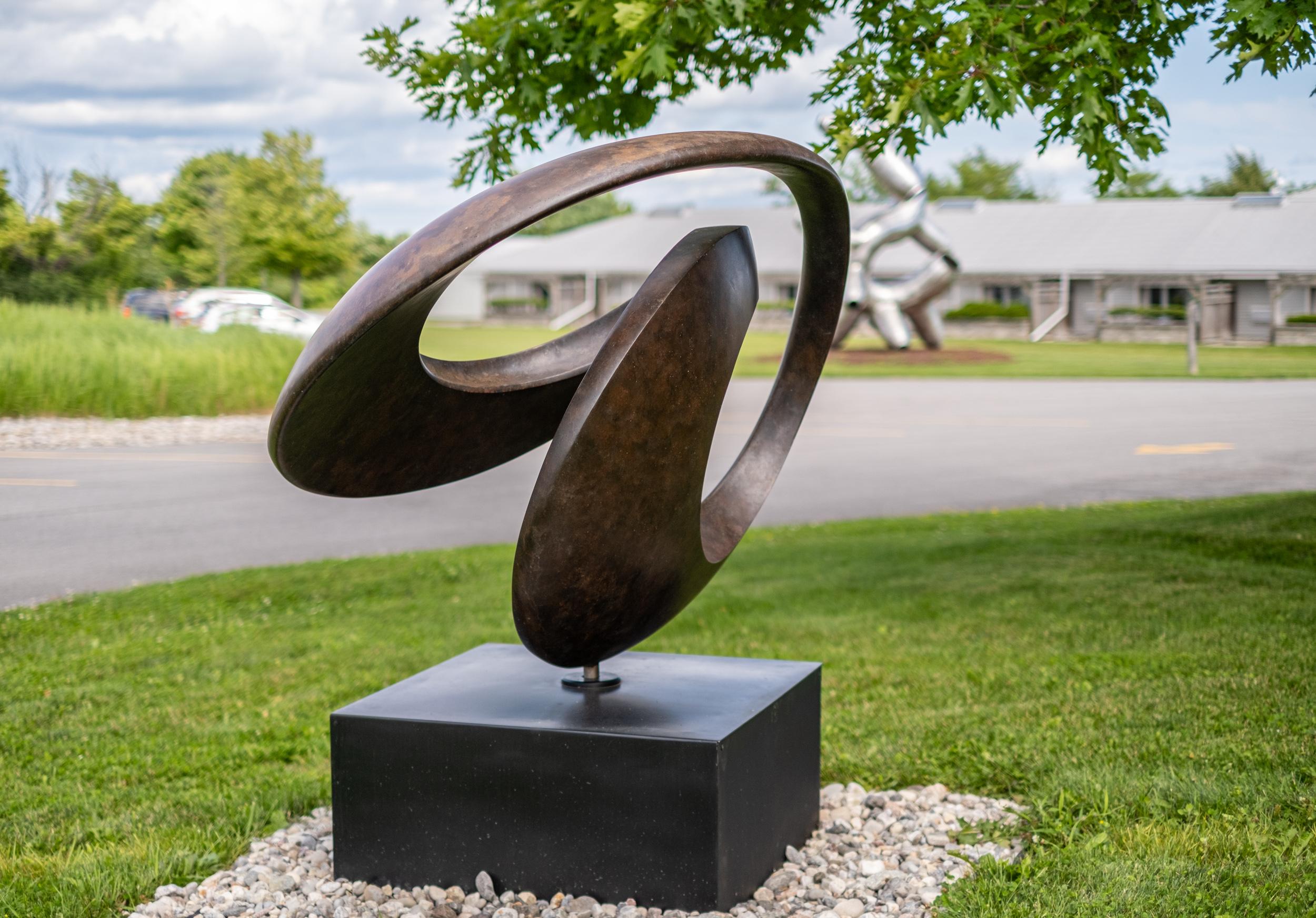This lyrical and elegant contemporary sculpture is by David Chamberlain whose work is collected and admired around the world. Hand forged in patinated bronze and steel, the flowing circular form is intended to represent the fluid, melodic form of
