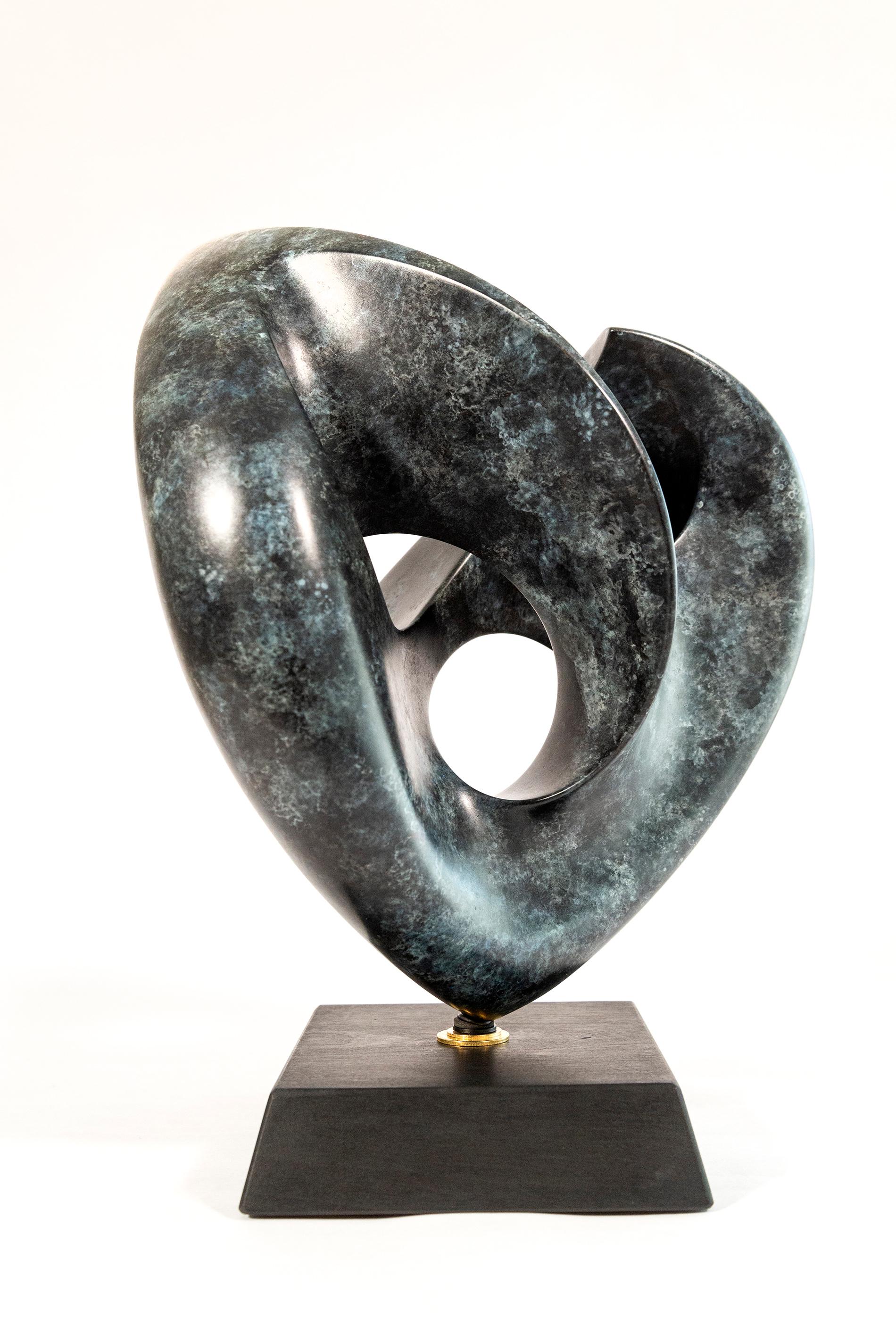 The lyrical lush lines of this heart-shaped bronze sculpture were created by the American artist David Chamberlain. Sculpted from one continuous piece, the highly patinated finish features flecks of turquoise in a dark bronze. Mounted on a wooden