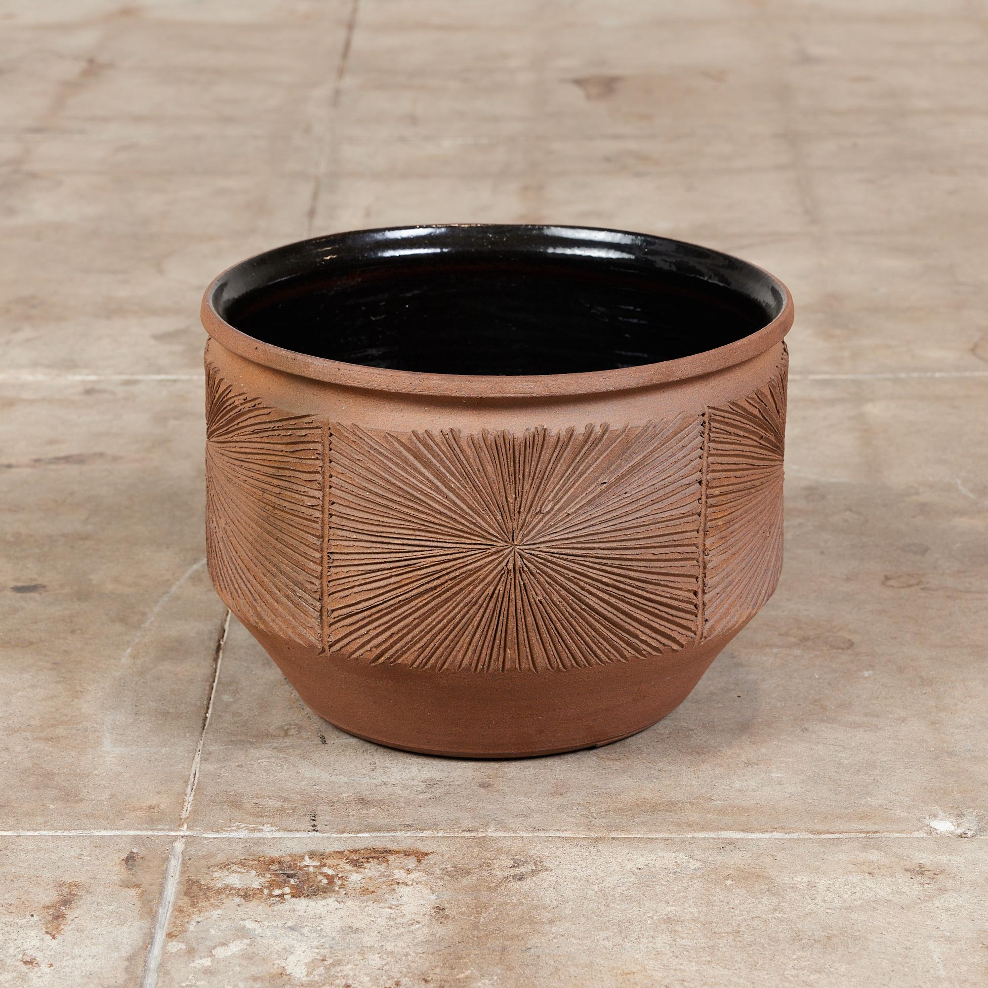 Hand thrown stoneware planter from Earthgender, David Cressey and Robert Maxwell’s early 1970s project. This 16” diameter example is incised in the “Sunburst” design a pattern of lines radiating from a central point. The interior of the planter has