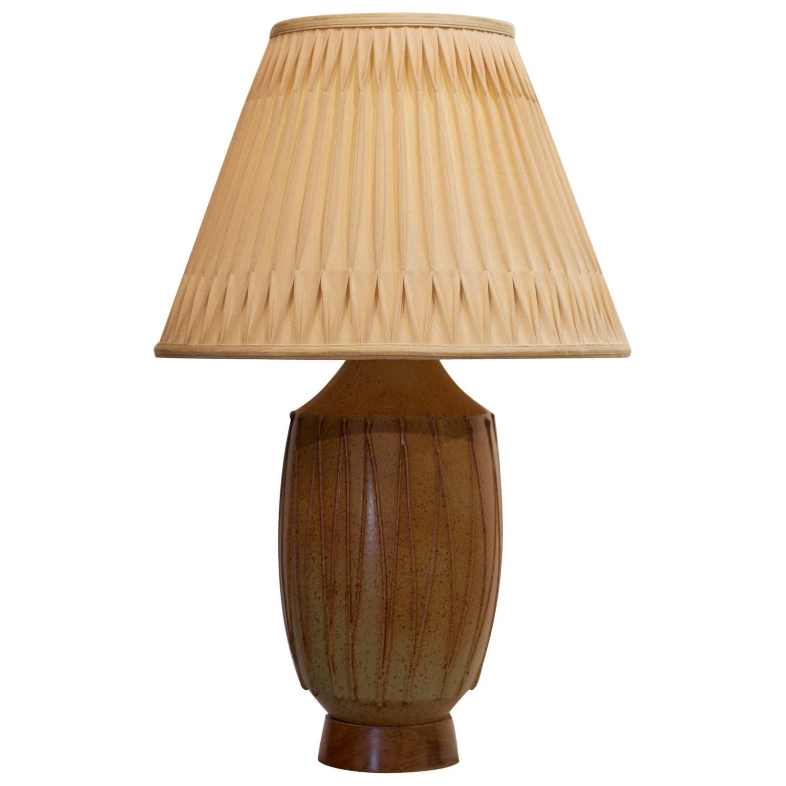 A handsome pottery lamp by esteemed California potter David Cressey, (1916-2013) for Architectural Pottery of California. The form is smart and classic with a speckled brown glaze over a light ochre base. All applied string glaze work is intact and