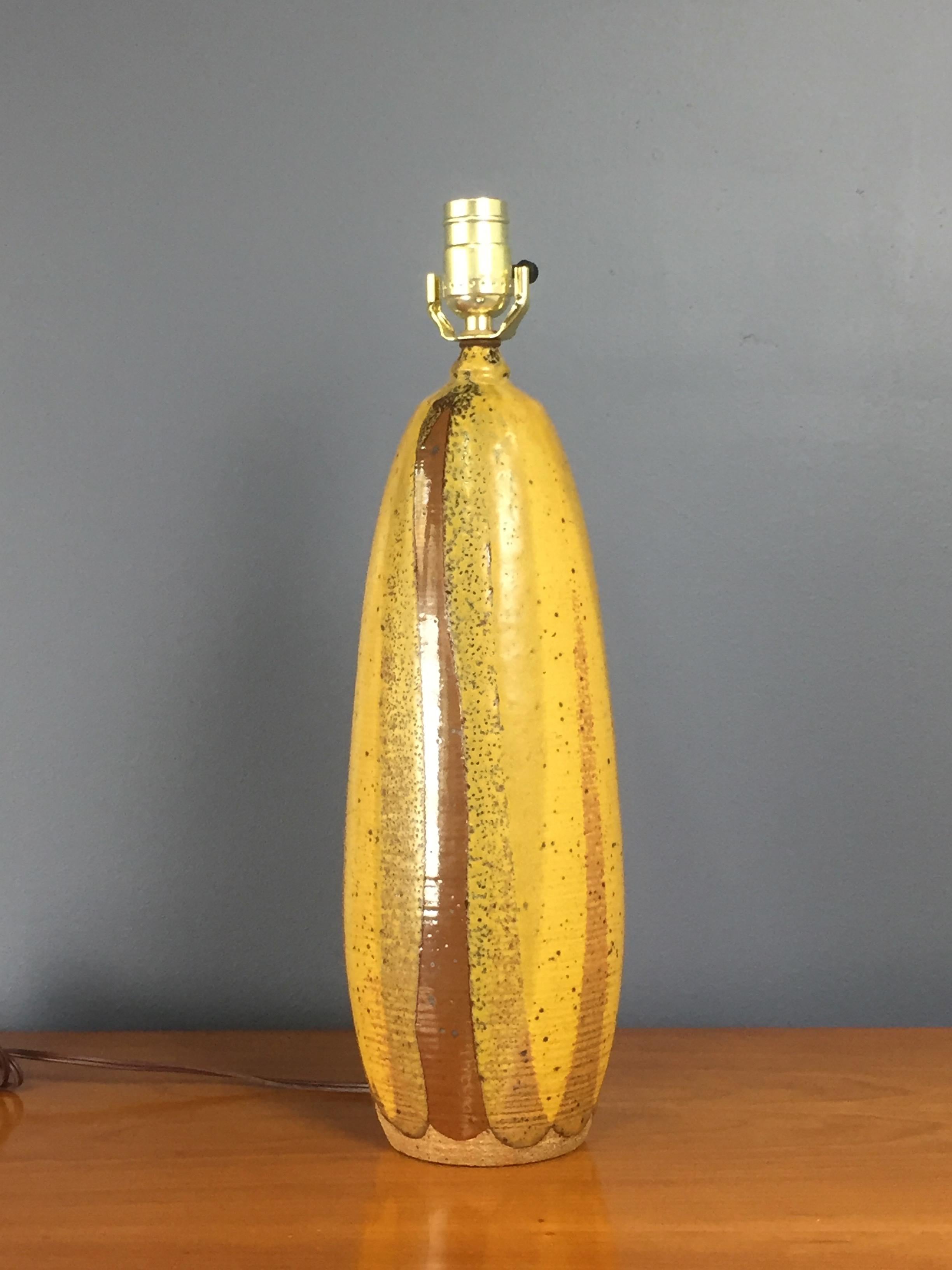 Beautiful ceramic table lamp by artist David Cressey for Architechtural Pottery, this lamp has yellow and brown hues with a textured glaze. The lamp is in excellent condition with no chips or cracks. The lamp measures 16