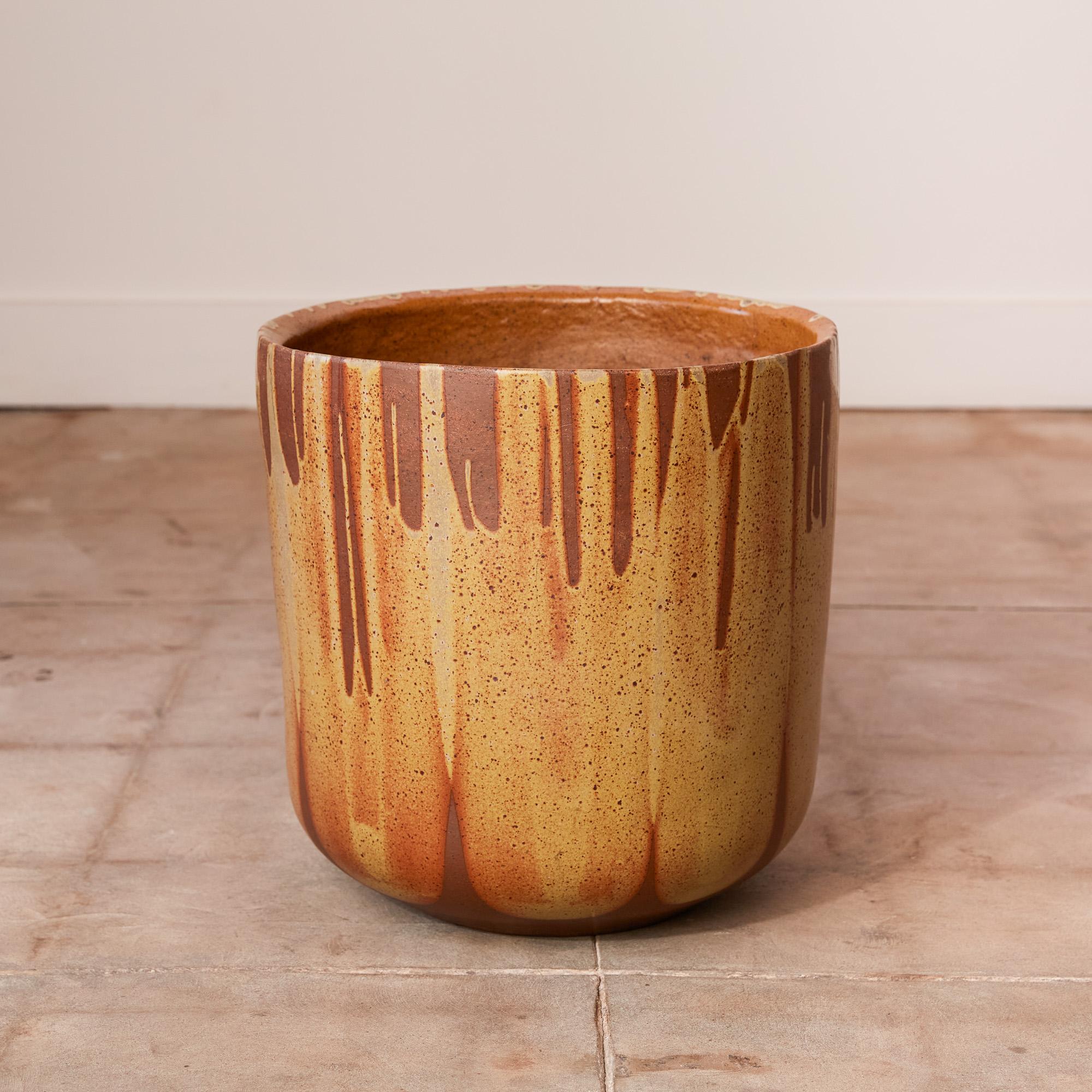 A tulip-shaped planter by David Cressey for the Pro/Artisan collection by Architectural Pottery with Cressey’s signature “Flame Glaze.” This planter has a rounded bottom that widens towards the opening, a simple shape rendered dramatic by the