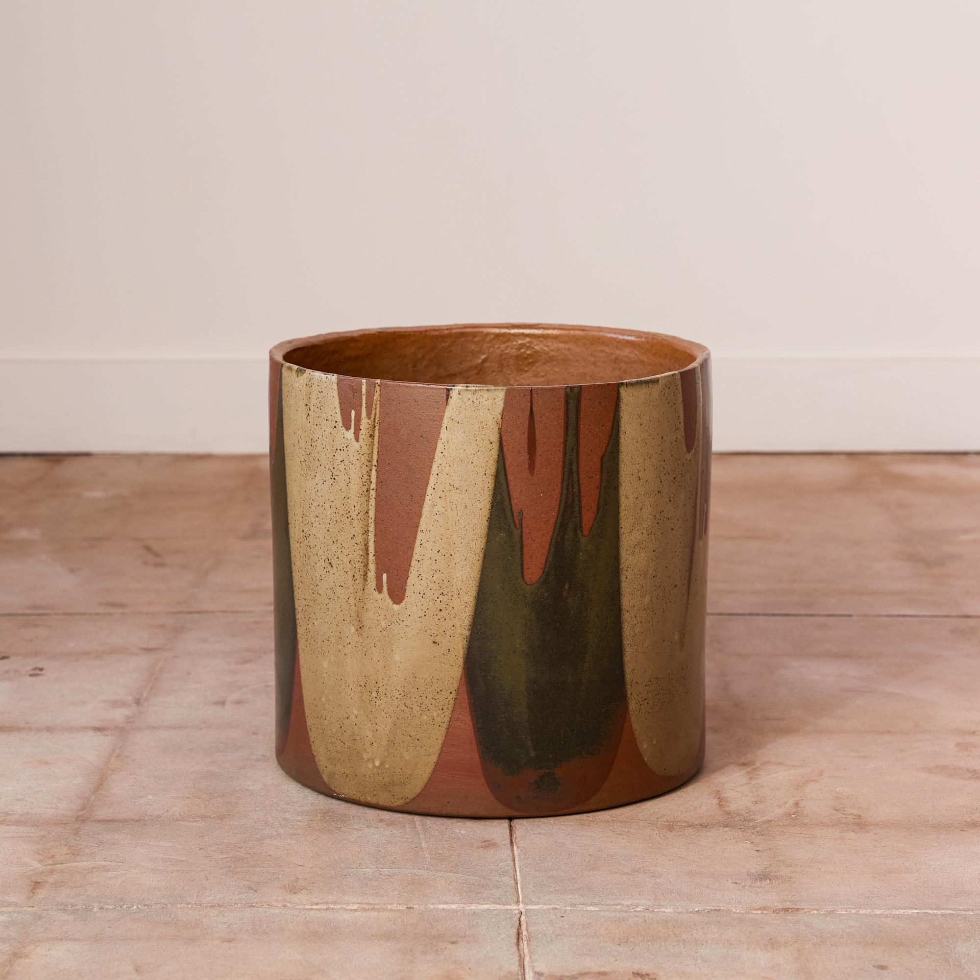 A planter by David Cressey for the Pro/Artisan collection by Architectural Pottery with Cressey’s signature “Flame Glaze.” This planter has a cylindrical body, a simple shape rendered dramatic by the variegated glaze pattern where drip lines
