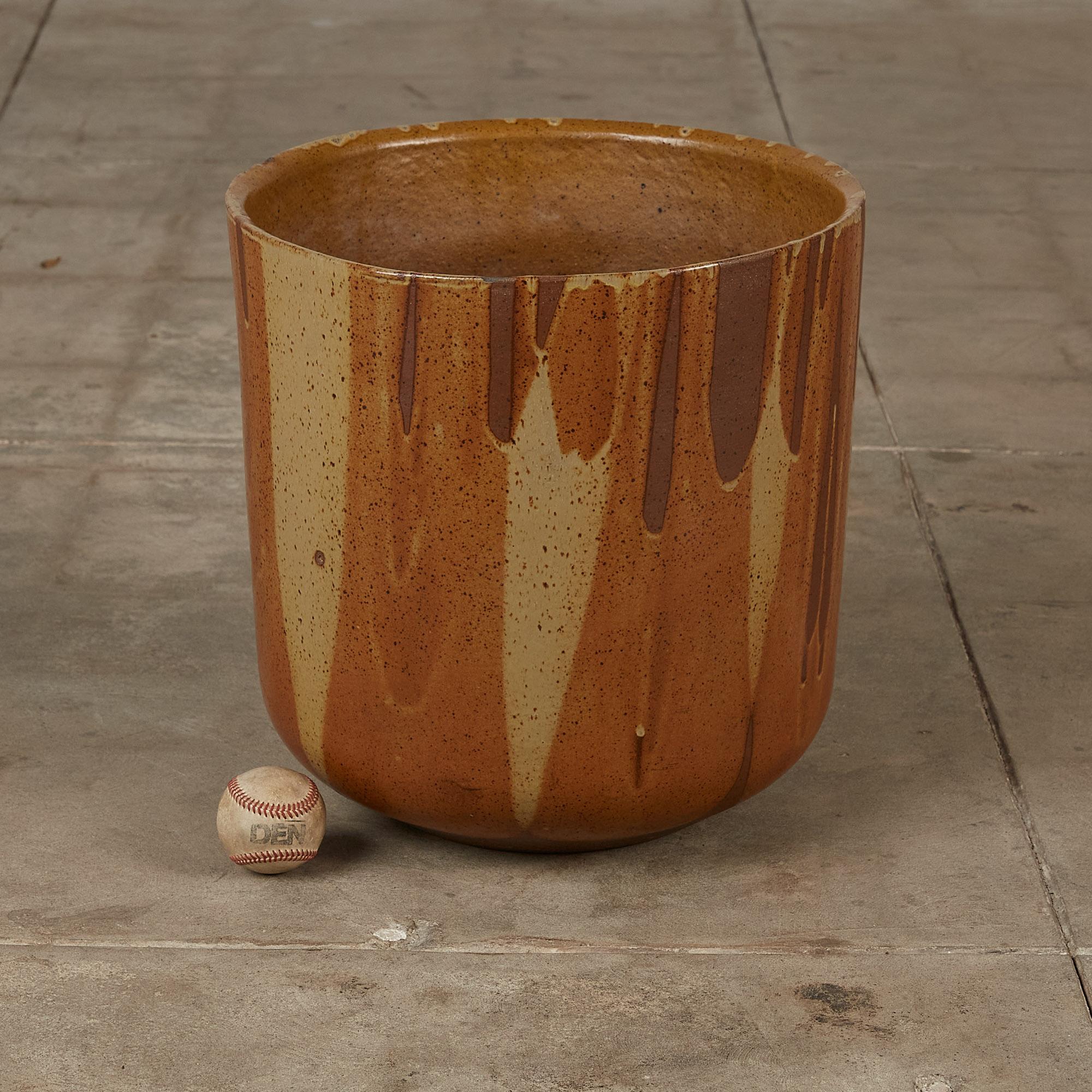 A tulip-shaped planter by David Cressey for the Pro/Artisan collection by Architectural Pottery with Cressey’s signature “Flame Glaze.” This planter has a rounded bottom that widens towards the opening, a simple shape rendered dramatic by the