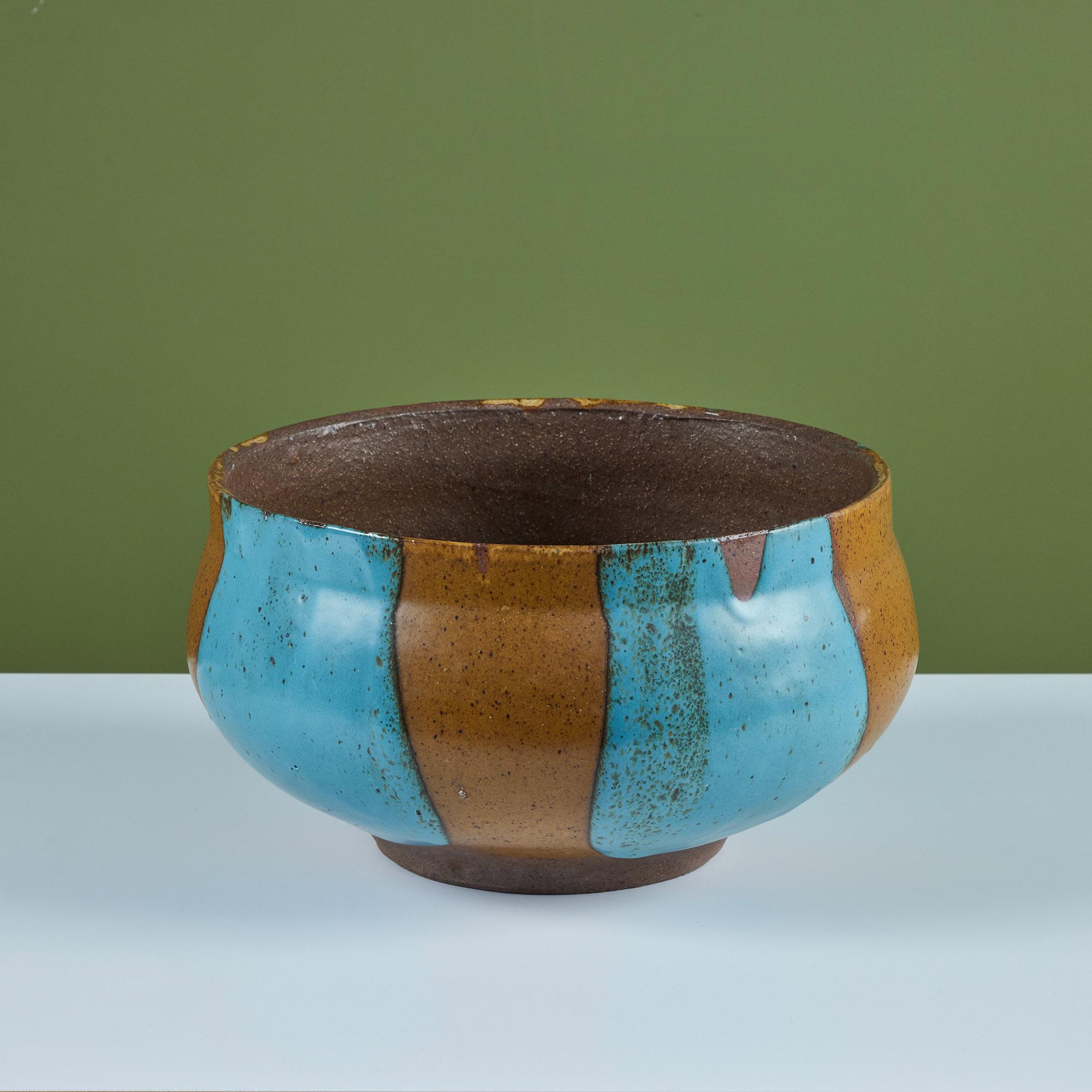 Stoneware planter by David Cressey for the Pro/Artisan collection by Architectural Pottery with Cressey’s signature “Flame Glaze.” This one showcases a lively turquoise and golden ochre speckled glaze. The bulbous form tapers towards the bottom with