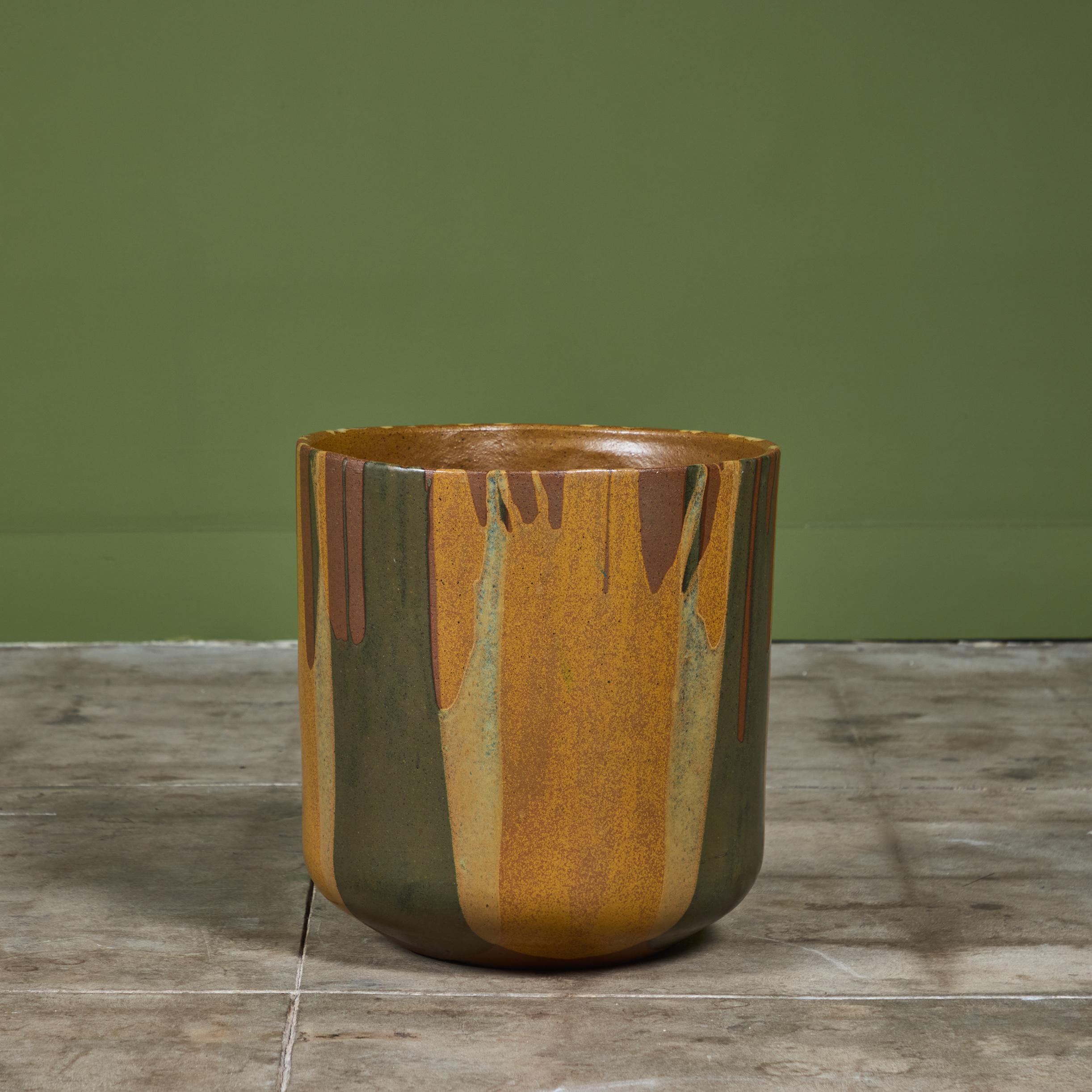 A tulip-shaped planter by David Cressey for the Pro/Artisan collection by Architectural Pottery with Cressey’s signature “Flame Glaze.” This planter has a rounded bottom that widens towards the opening, a simple shape rendered dramatic by the