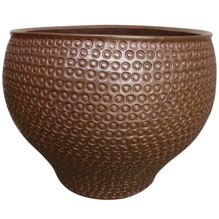 An attractive bell curved brown glaze planter for the home or professional setting. David Cressey adds circular imprint decoration on the vessel originally released by Architectural Pottery, circa 1960.