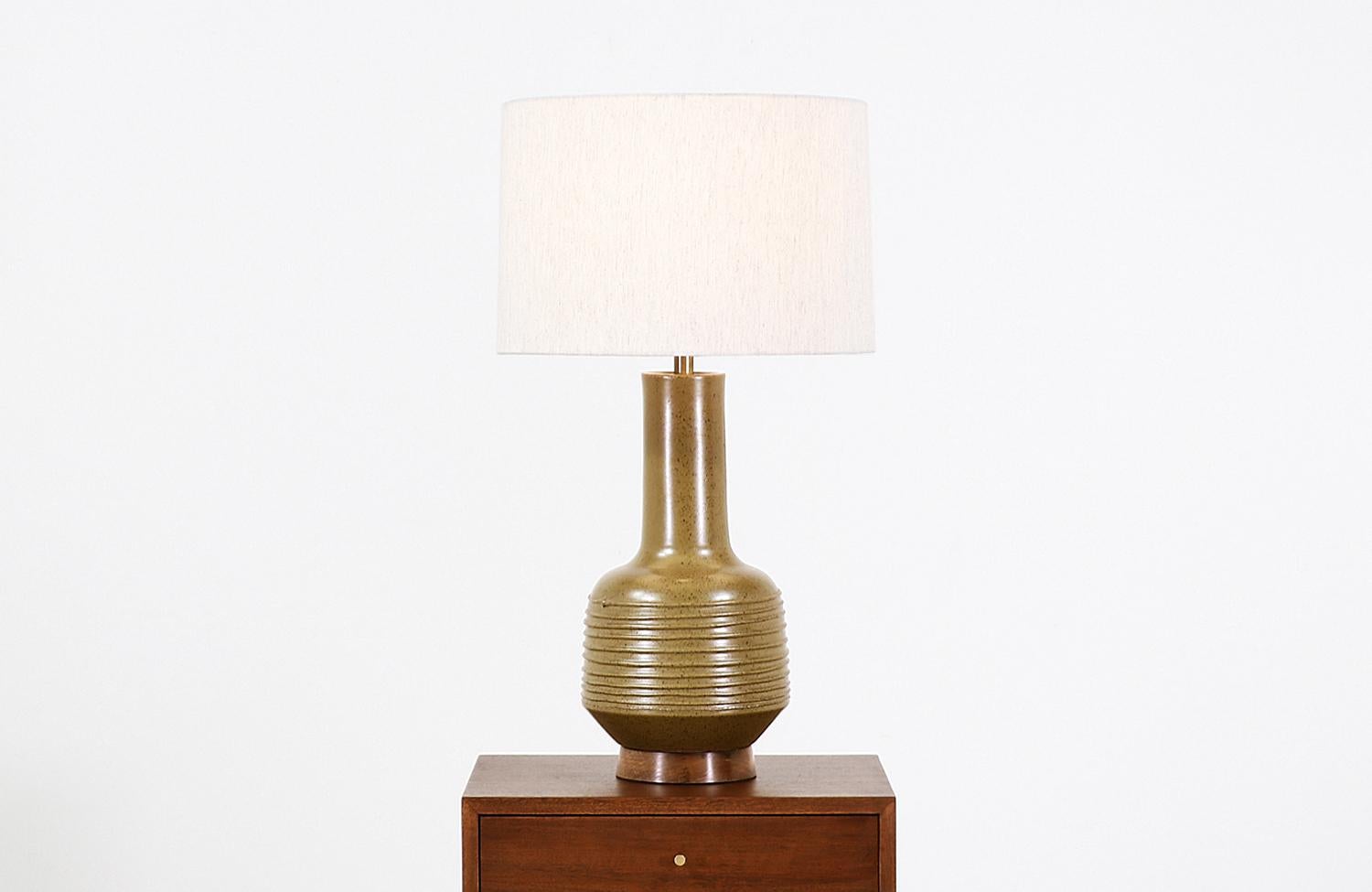 Similar lampshade included

Ceramic table lamp designed by David Cressey for Architectural Pottery in California in the 1970s. This elegant midcentury table lamp with brown speckles against its olive green ceramic body features a horizontal string
