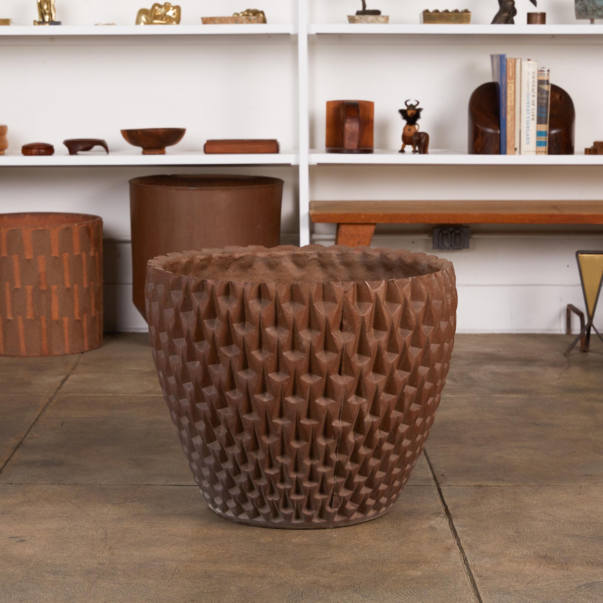Designed by David Cressey in 1963 as part of the Pro/Artisan stoneware collection for Architectural Pottery, the slip cast Phoenix planter has a bowl shape with an all-over geometric relief. This example is finished in unglazed stoneware emphasizing