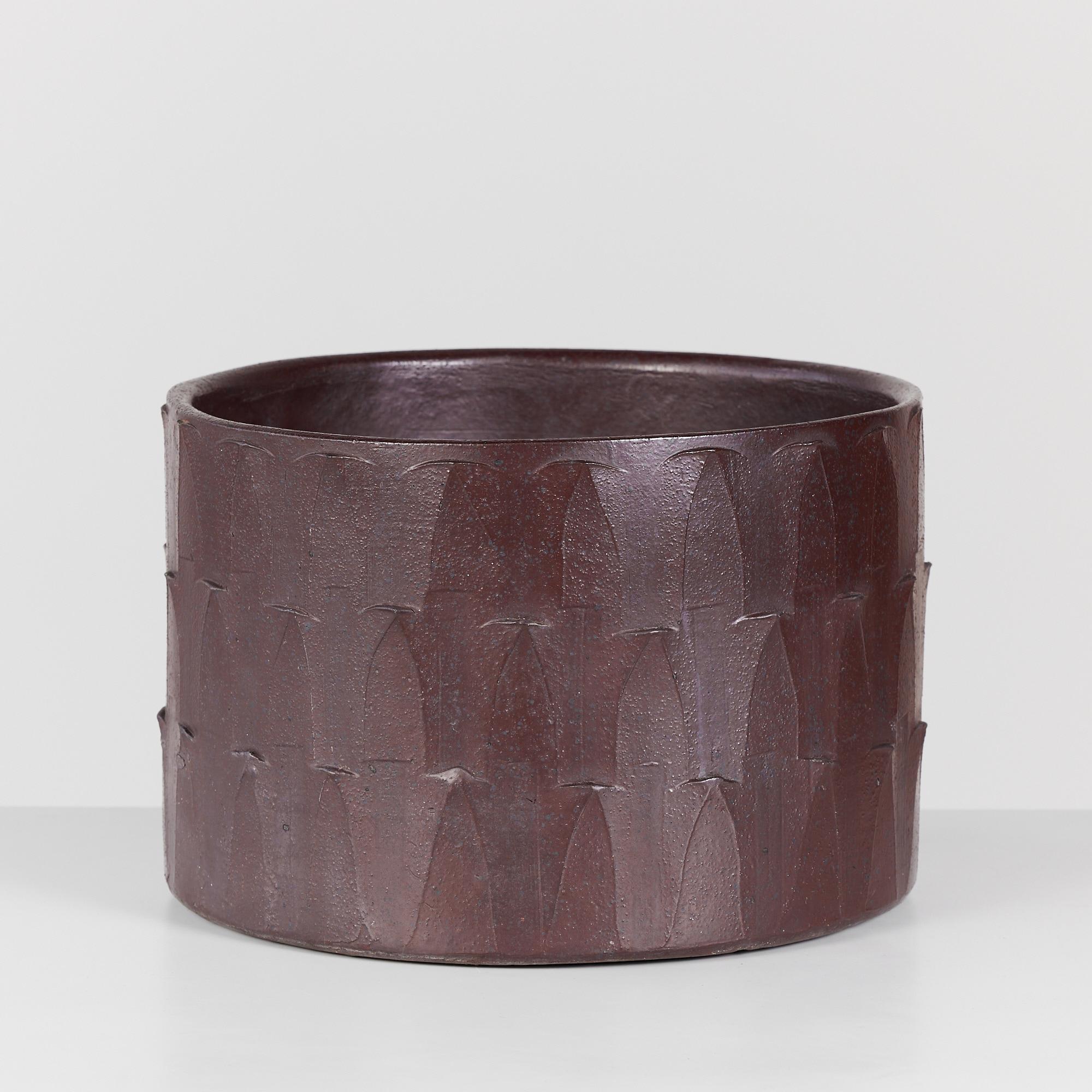 Cylindrical ribbed planter by David Cressey from the Pro/Artisan collection for Architectural Pottery. This plum colored planter has a soft speckled glazed interior and exterior with one drainage hole at the bottom center. 

Dimensions
16.25