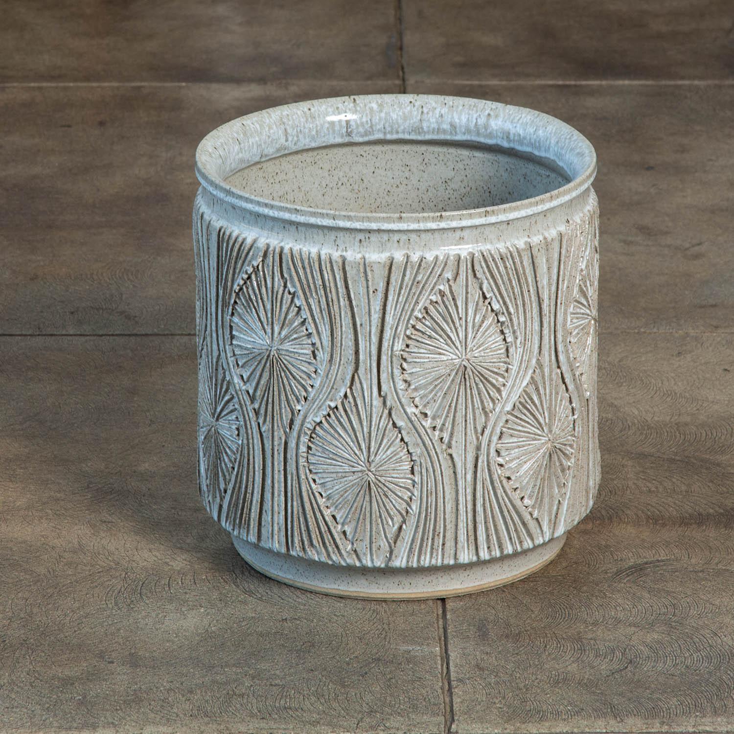 A cylindrical planter from Earthgender, David Cressey and Robert Maxwell’s early 1970s project. This 15” diameter example is incised in the “Teardrop Sunburst” design with interlocking gestural curves separating a pattern of lines radiating from a