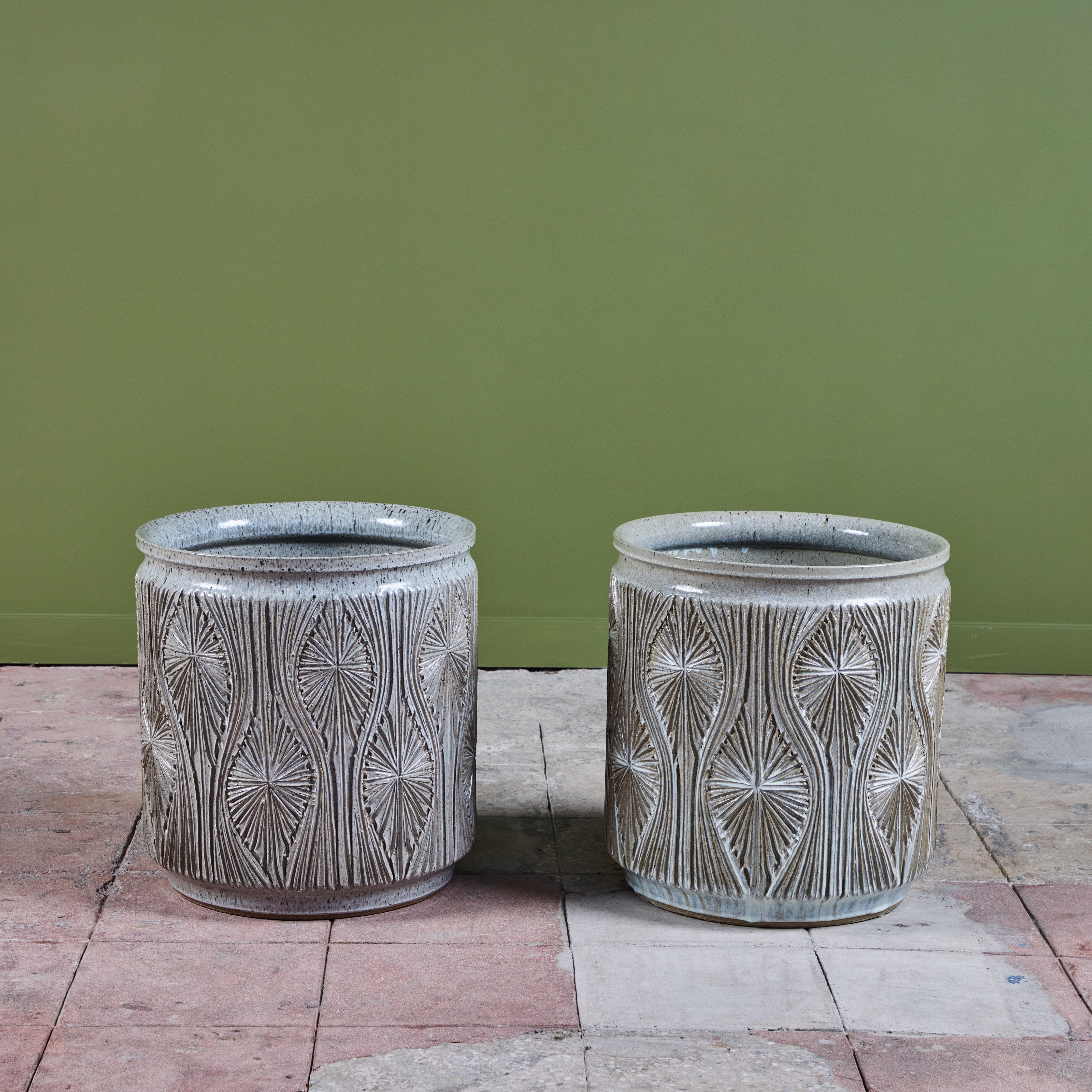 Cylindrical pair of planters from Earthgender, David Cressey and Robert Maxwell’s early 1970s project. These 17.75” diameter examples are incised in the “Teardrop Sunburst” design with interlocking gestural curves separating a pattern of lines