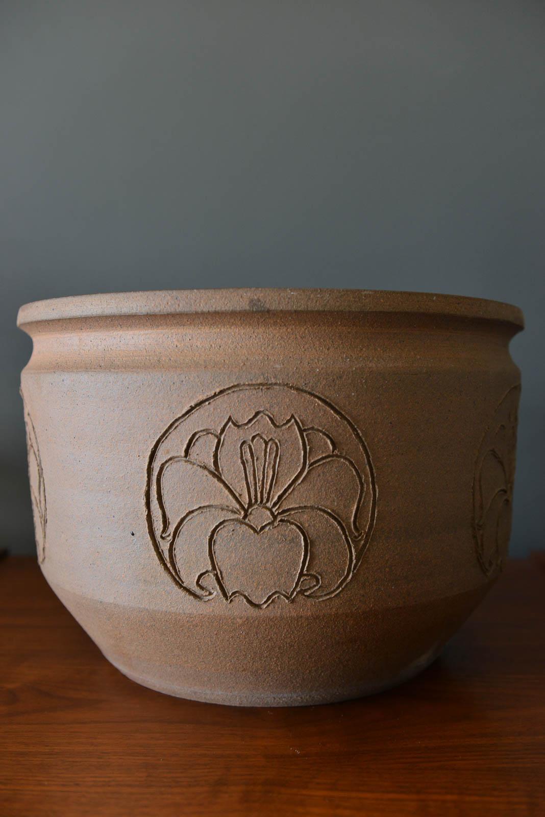 David Cressey Robert Maxwell incised flower motif planter, circa 1970. Glazed on the inside with a nice black finish and hand-incised with 5 orchid motifs around the entire body. Measures 14.5