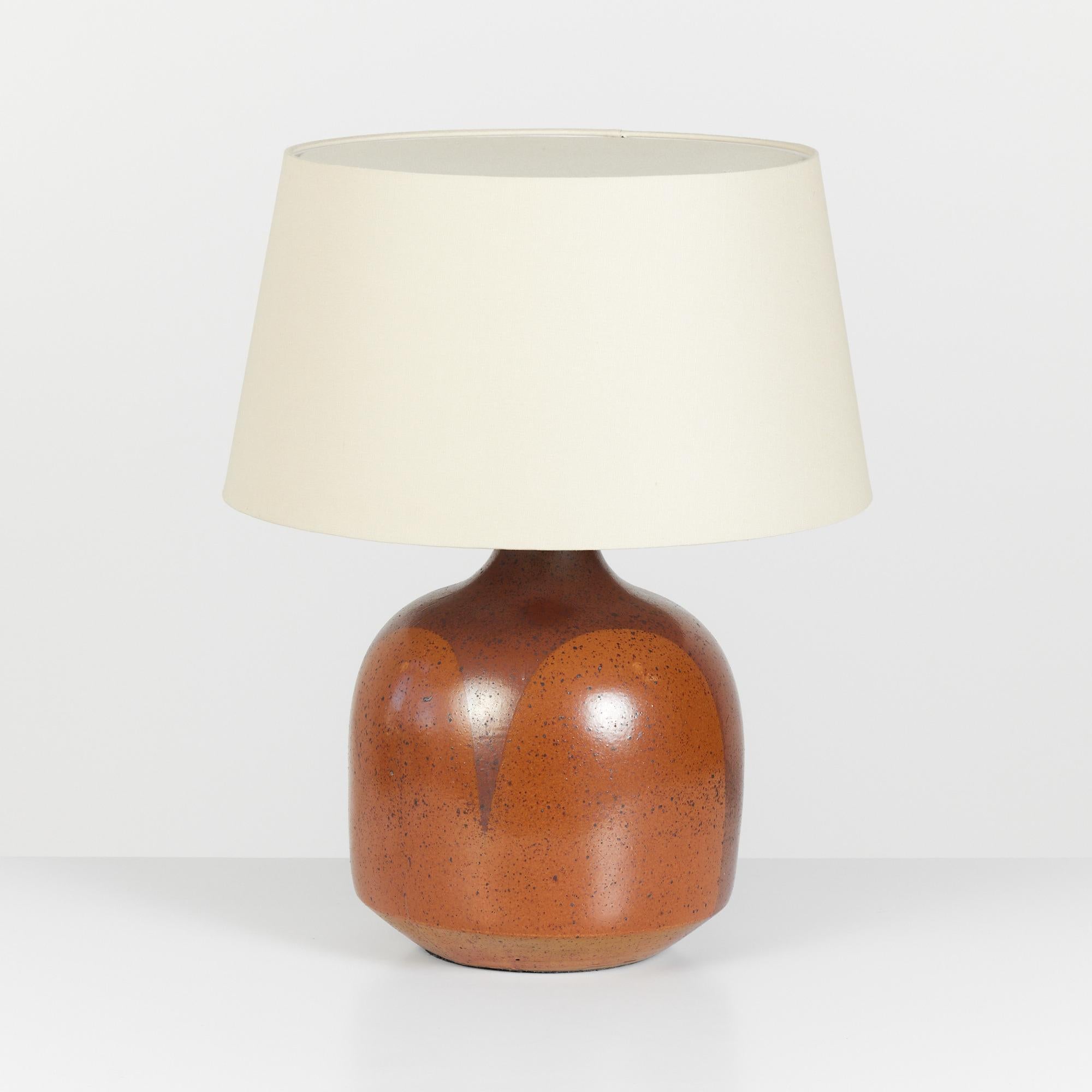 David Cressey flame glaze lamp, circa 1960s, USA. The wheel thrown stoneware lamp features a speckled flame glaze detail. The burnt orange and brown glaze pattern drip lines terminate near the base of the lamp, mimicking the pattern of flames. The