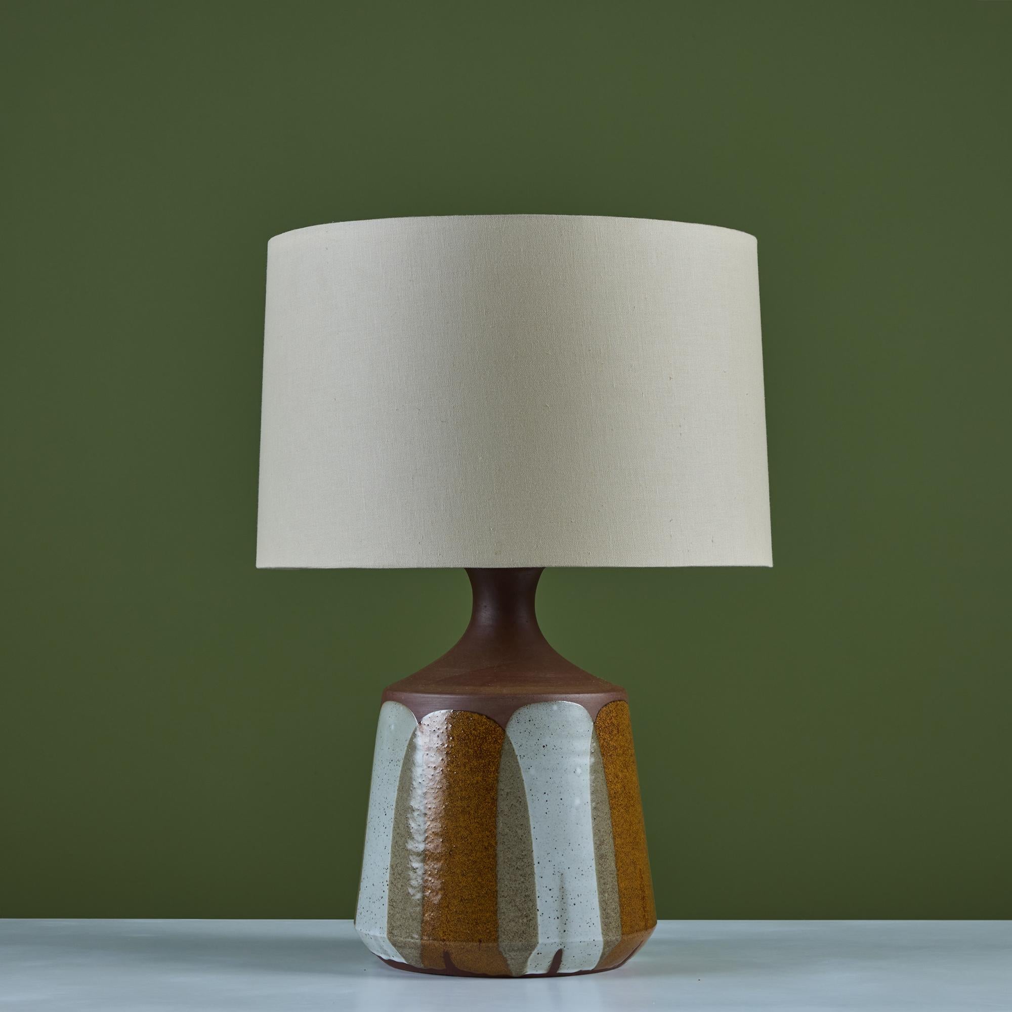David Cressey flame glaze table lamp, c.1960's, USA. The wheel thrown stoneware lamp features a speckled flame glaze detail. The cream and brown glaze pattern drip lines terminate near the base of the lamp, mimicking the pattern of flames. The newly