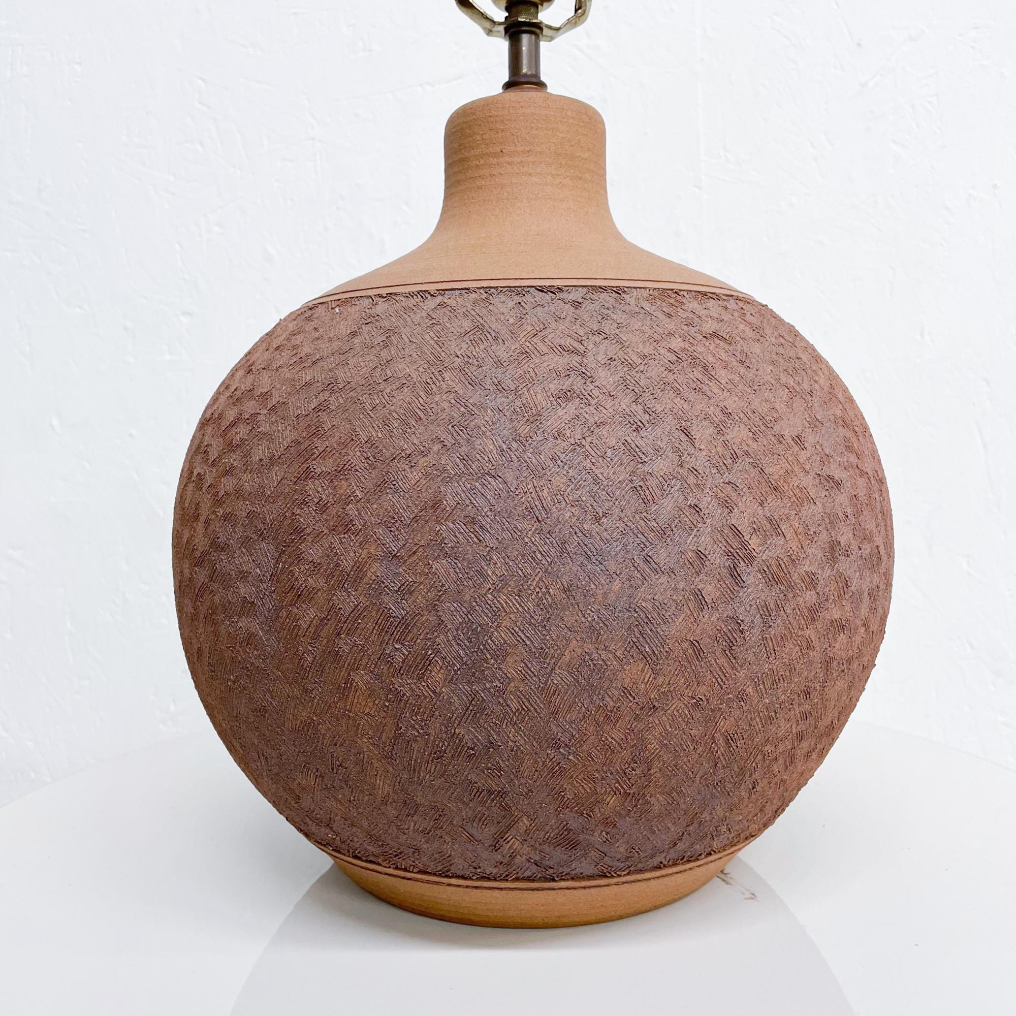 Bulbous texturized table lamp Mid-Century Modern Pottery signed Brown circa 1970s
Unglazed. In the style of David Cressey USA.
Measures: 18 H to the base of the socket x 15 in diameter
Original unrestored vintage condition. Refer to images