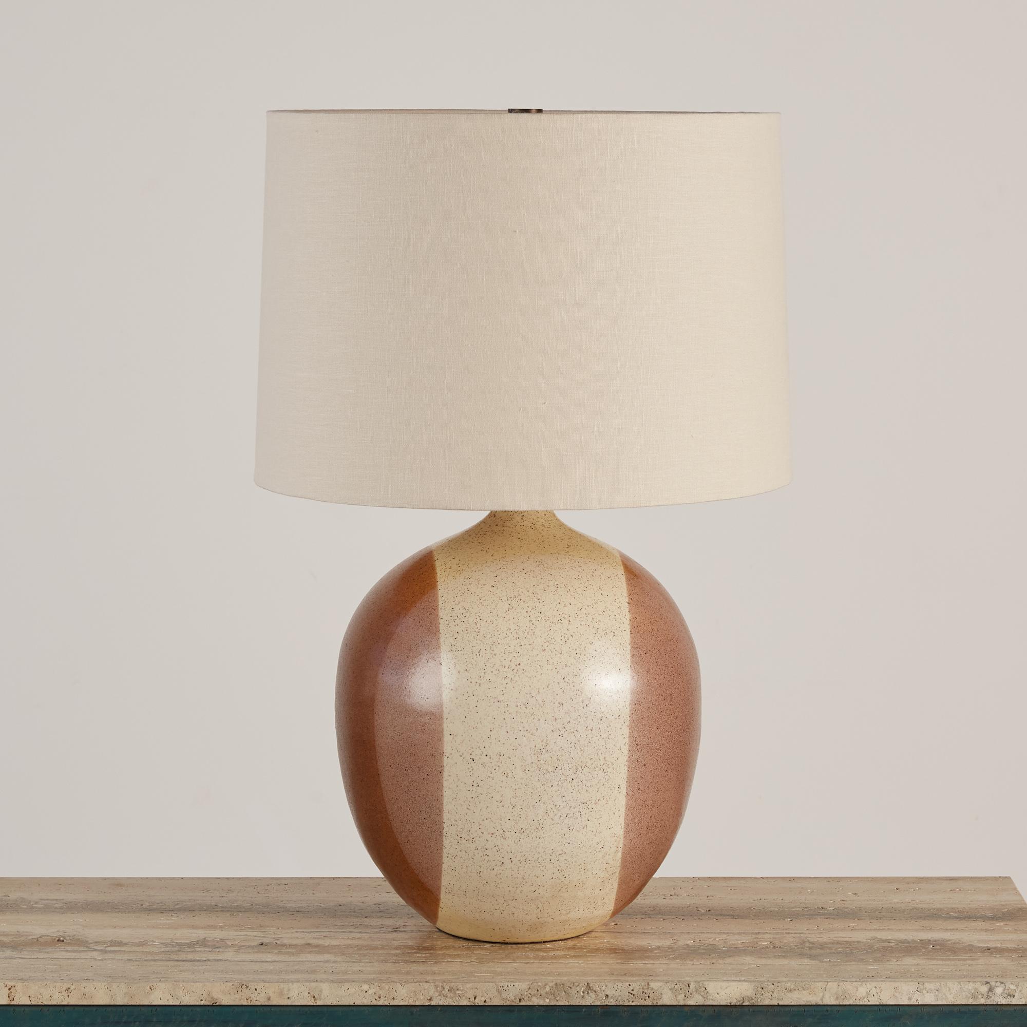 David Cressey style ceramic table lamp with vertical blocked speckled glaze in neutral cream and brown tones. The newly rewired lamp features a new linen shade. The shades and diffuser are secured by a patinated bronze finial.

Dimensions: 18”
