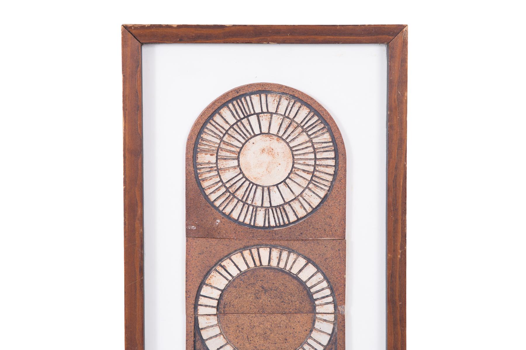 David Cunningham studio framed 1970s ceramic wall piece in white, tan and warm brown tones. The artwork illustrates a sun and sunflower motif. Artwork has David Cunningham Gallery & Studio label on back.