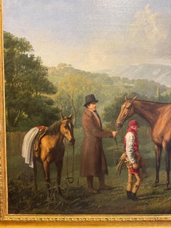 Un cavallo da corsa tenuto in braccio dal suo allenatore e dal suo fantino presentato al proprietario