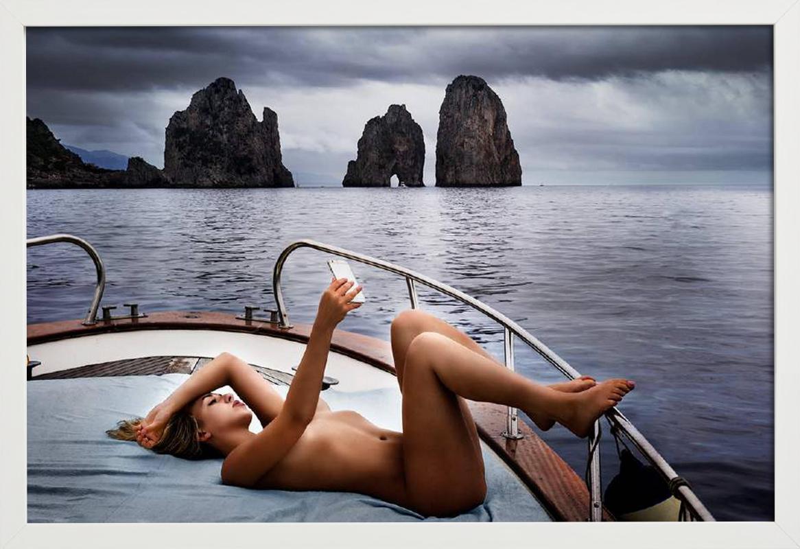 Capri Selfie – nackt auf einem Boot unter wolkenverhangenem Himmel, Kunstfotografie, 2016 (Grau), Color Photograph, von David Drebin