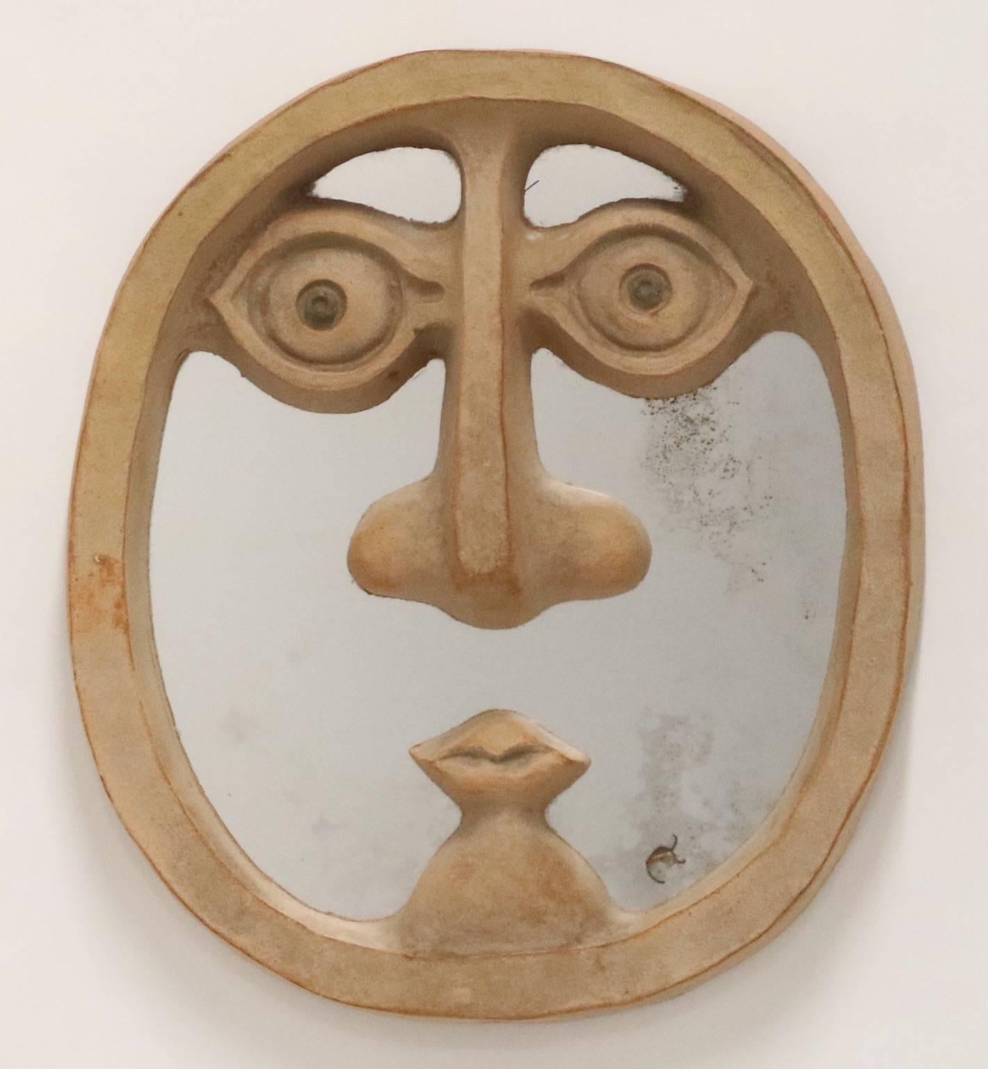 Mid-Century Modern mirror by David Gil for Bennington Pottery with unglazed ceramic stylized face. This mirror dates from the 1960s and is in good vintage condition with wear consistent with age and use. The mirror shows signs of age.