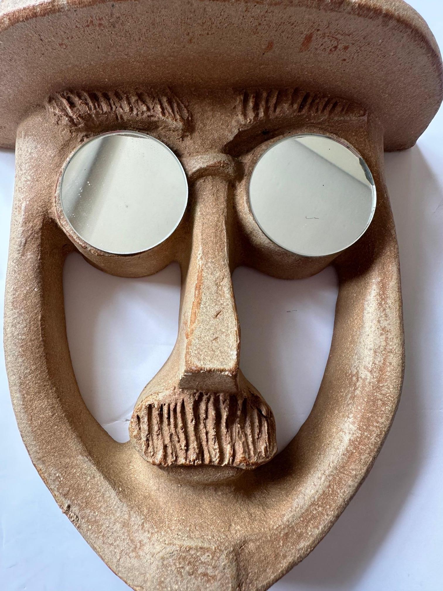 Fun pottery wall sculpture of man with bowler hat and mirror eyes by David Gil of Bennington Pottery.

A whole collection is available. 