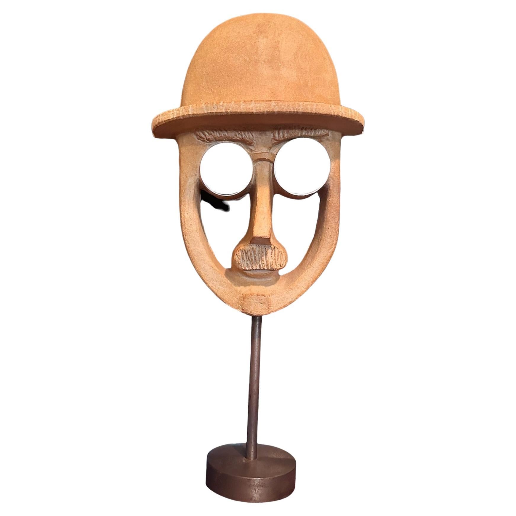 Man in bowler hat with glasses on and moustache the glasses are mirrors applied made of ceramics with a burnt orange glaze signed on back in stamp 
