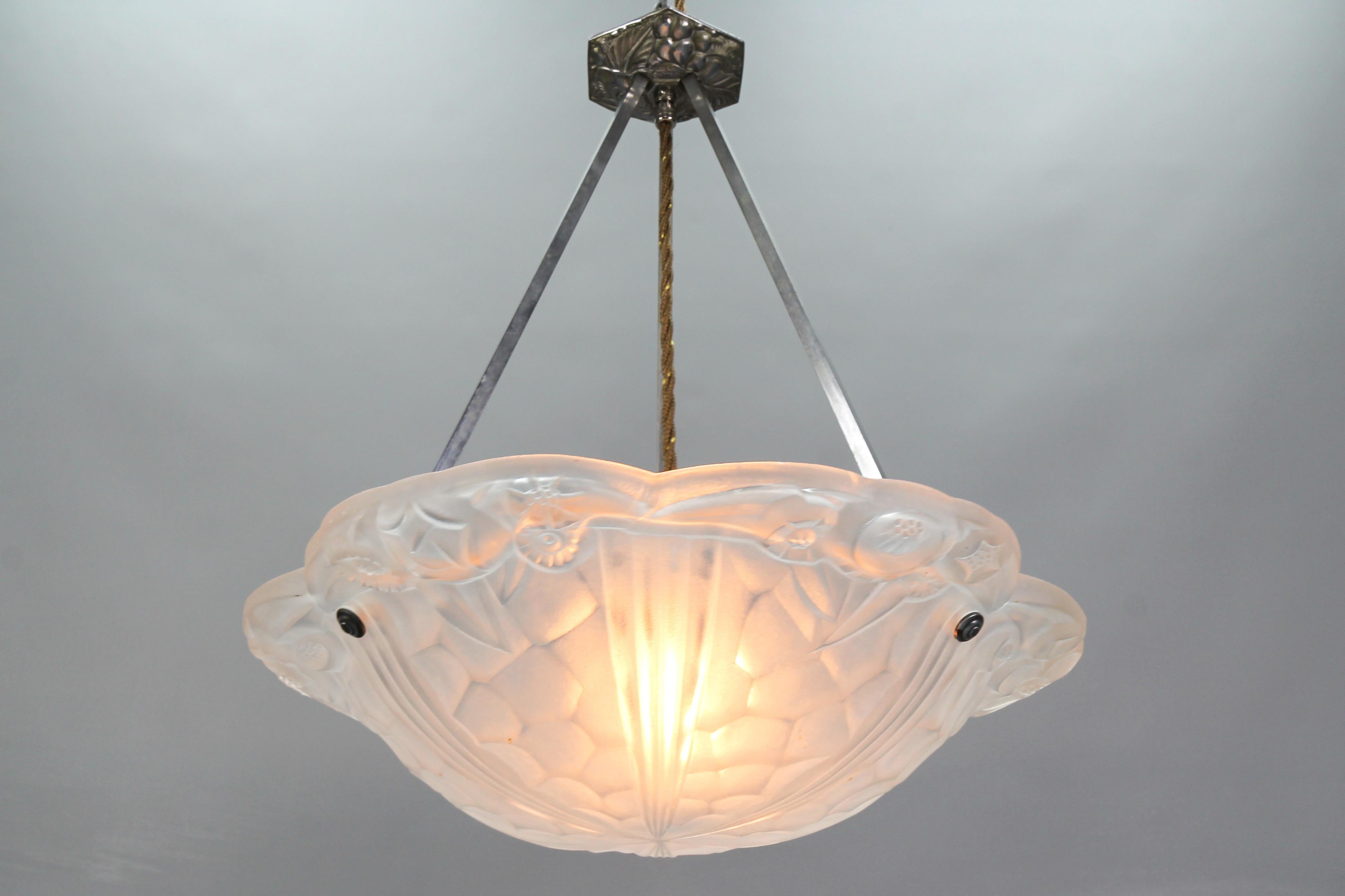 French Art Deco pendant light with white frosted glass shade signed Degué by Verrerie D'Art Degué. 
Beautifully shaped glass lampshade features a relief of stylized flower motifs, the glass surface signed 