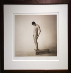 Nu masculin debout : photographie de portrait sépia dans un cadre en bois