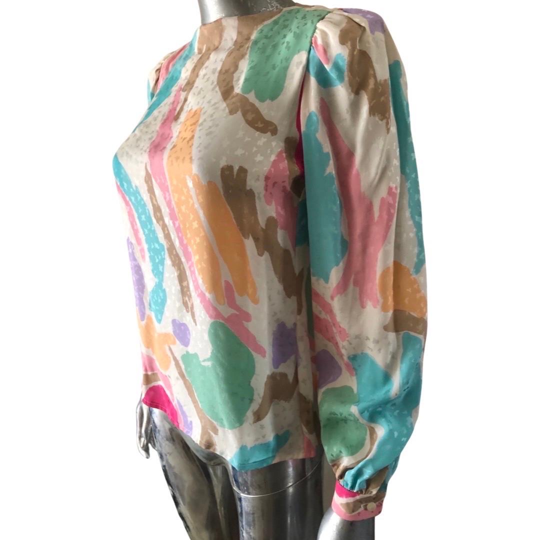A lovely classic silk blouse with matching scarf by David Hayes. As new (without tags). Ling sleeve blouse has clean crewneck. Tie can be used as a scarf around neck or waist. Size 4. Made in the USA. Coordinating jacket (NWT) and skirt available on