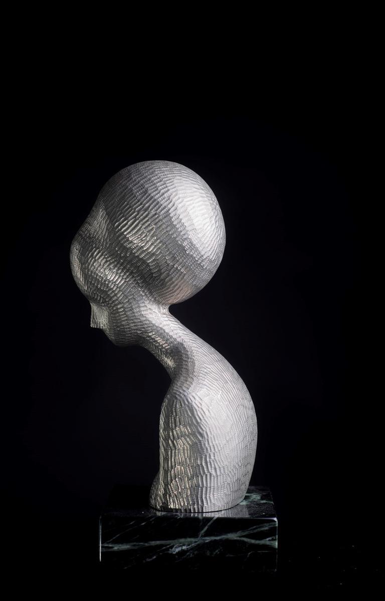 Bust of Quiet Woman is cast nickel. The surface was then re-carved to accent each of the original marks in the wood. This is the only Hostetler sculpture ever cast in nickel and the only one with a re-carved surface.  The series of Quiet Woman