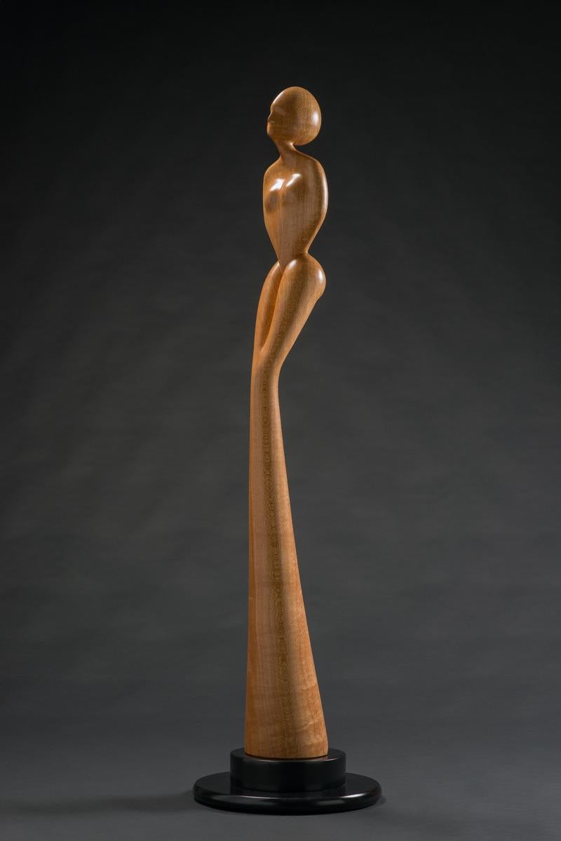 A stunning figure carved from a single section of lacewood. Natural color finish. The base is a 2 level disk, 5