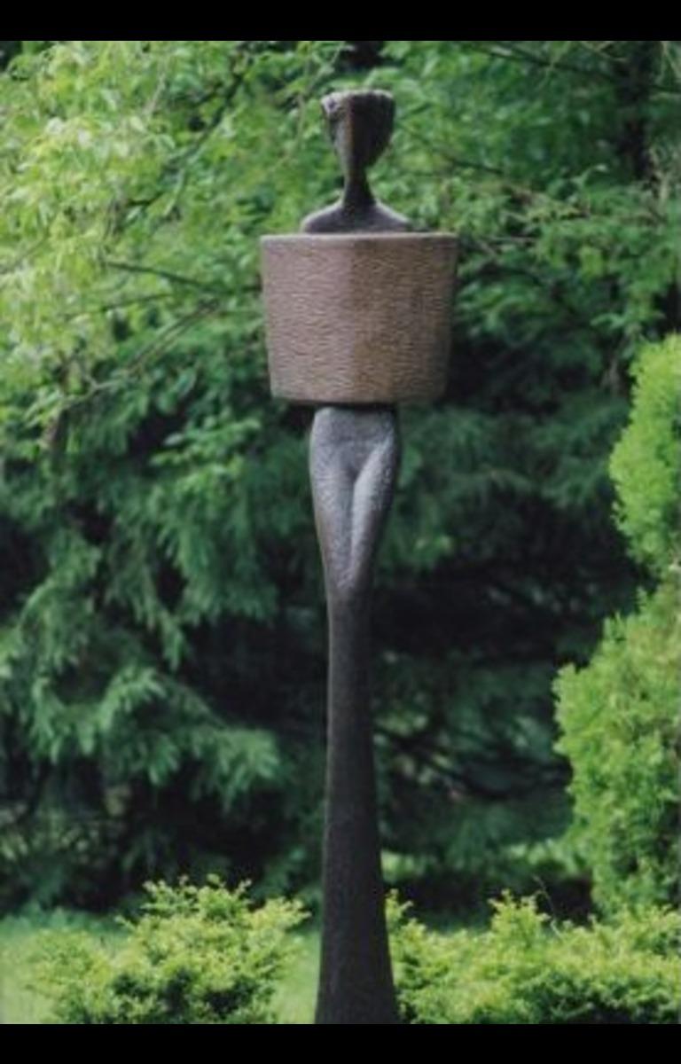 Tribal Figure is a bronze cast from a wood carving. The bronze base is cast from an antique mill stone and it is attached to a steel disk to bolt down the sculpture. 
It is part of the Semaphore sculpture series. David was studying Jungian