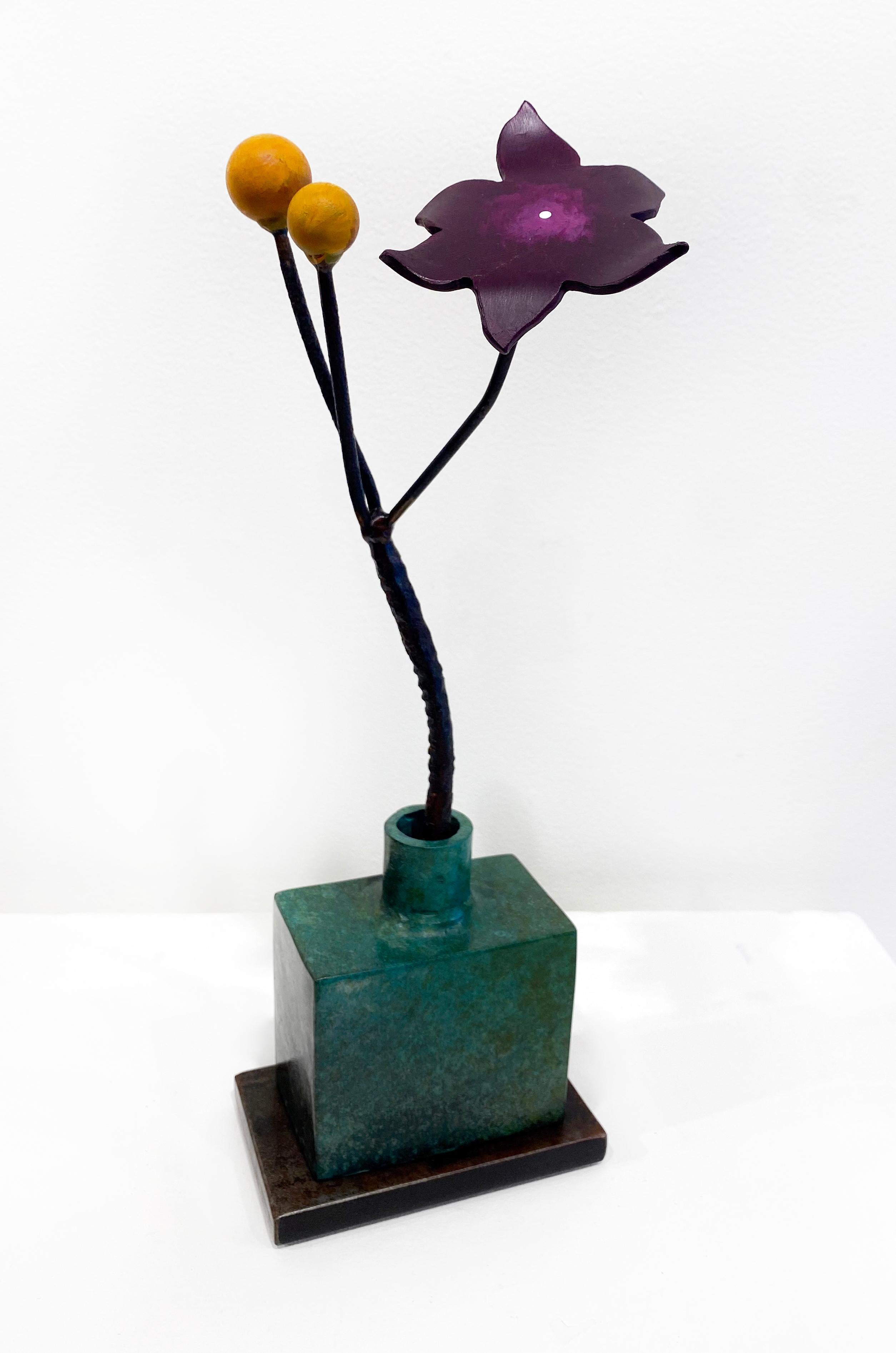 'Green Bottle Ochre Seeds' de David Kimball Anderson, 2022. Bronze, acier et peinture, 16 x 6 x 5 in. Cette sculpture présente un  vase carré moulé en bronze et fini avec une patine verte. Il s'agit d'une fleur en acier peinte en violet avec deux