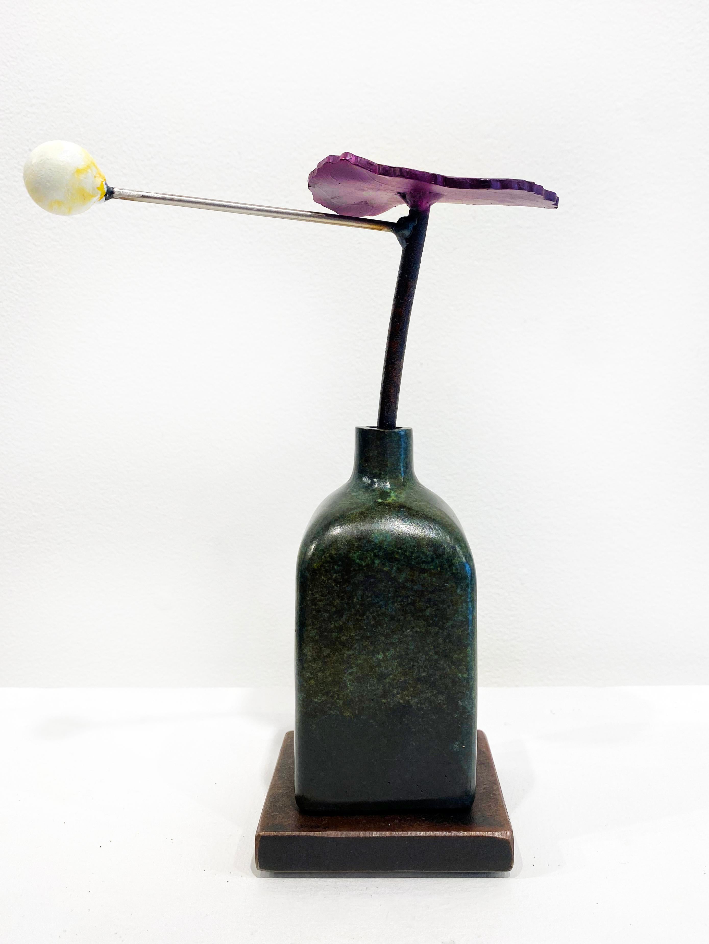 'Planet Purple Zinnia' by David Kimball Anderson, 2022. Bronze, steel, and paint, 7 x 6 x 4 in. This sculpture features a rounded square vase cast in bronze and finished with a green patina. It features a steel flower painted in purple and a white