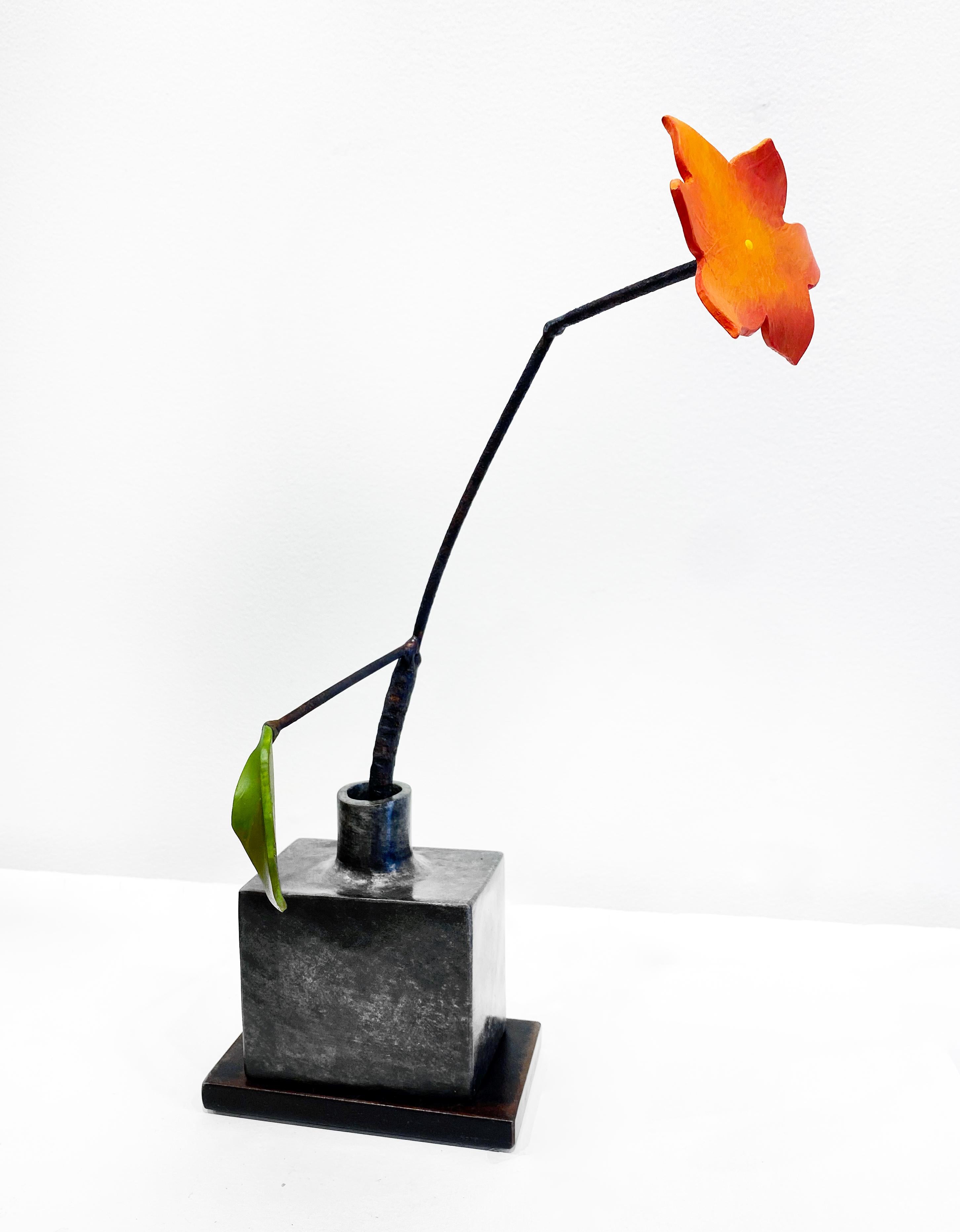 'Silver Bottle Orange Flower' von David Kimball Anderson, 2022. Bronze, Stahl und Farbe, 18 x 10 x 5 Zoll. Diese Skulptur zeigt eine  quadratische Vase aus Bronze gegossen und mit grauer Patina überzogen. Es zeigt eine orangefarbene Stahlblume und