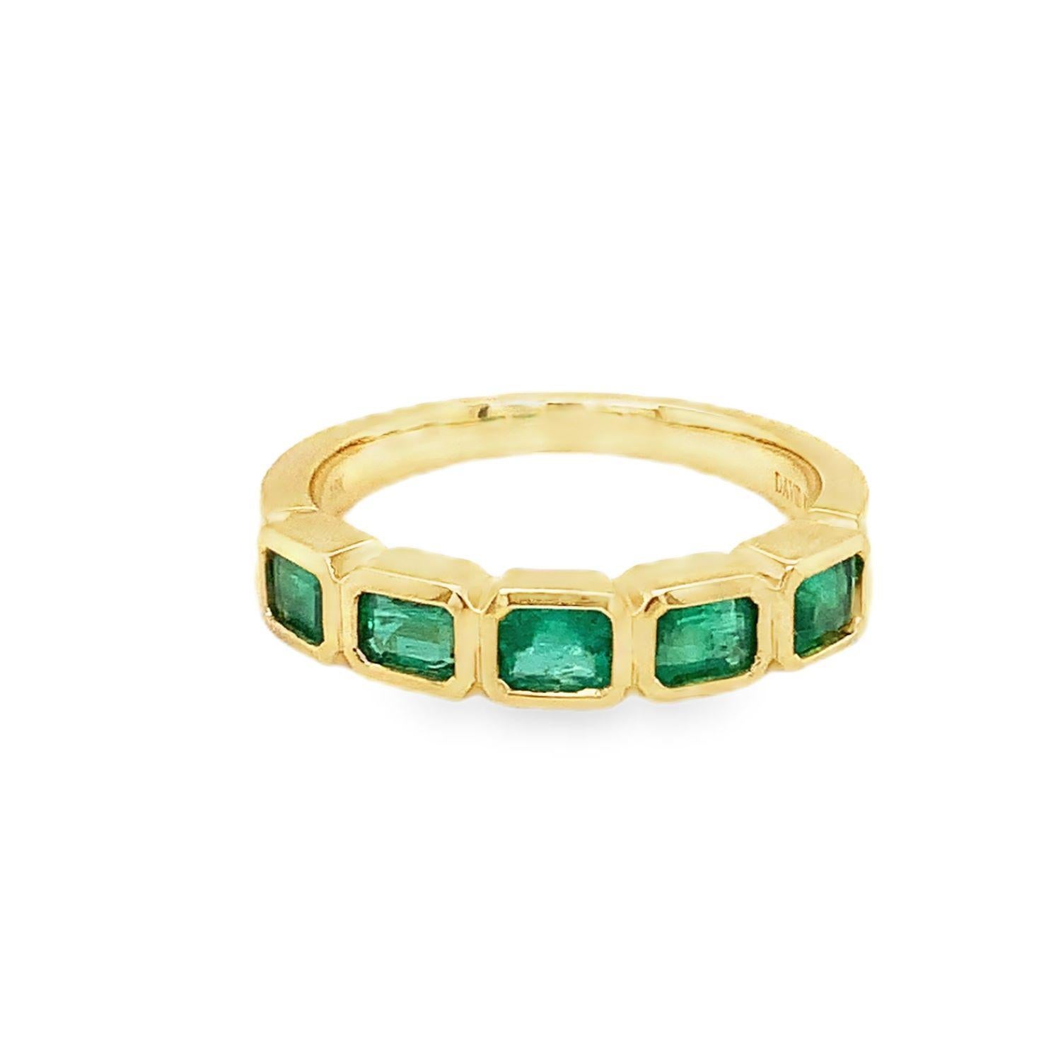 Smaragdband-Ring. Dieses auffällige Design zeichnet sich durch eine Reihe von Smaragden im Smaragdschliff aus, die jeweils in eine schlanke Lünette eingefasst sind. Das aus 18 Karat Gelbgold gefertigte Band zeigt einen leuchtend grünen Farbton der