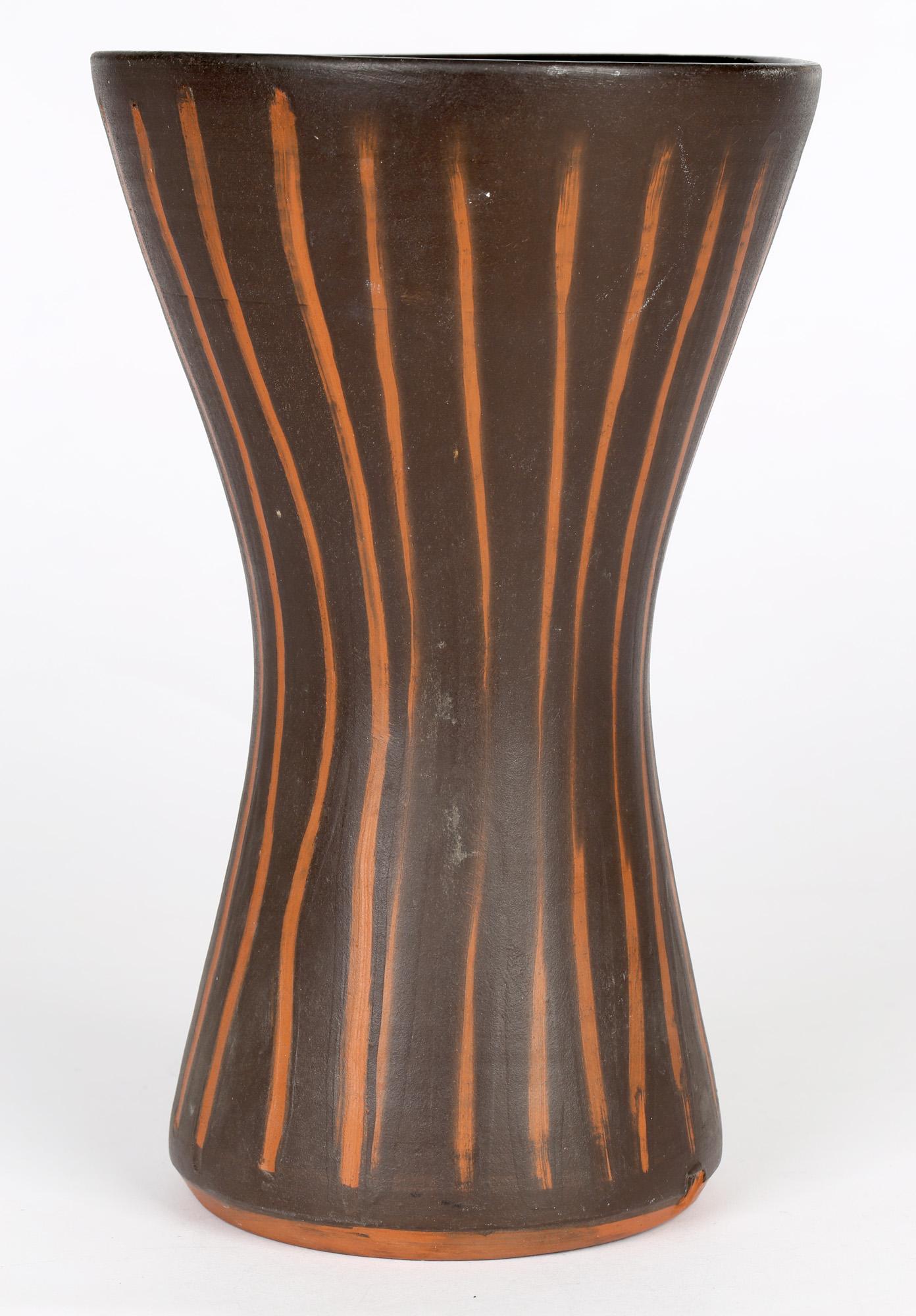 Un beau et inhabituel grand vase de poterie d'atelier de forme effilée avec des rayures verticales contrastées sur un fond brun foncé par David Leach (1911-2005) et probablement réalisé dans les premiers jours de Lowerdown vers 1960. Le vase est