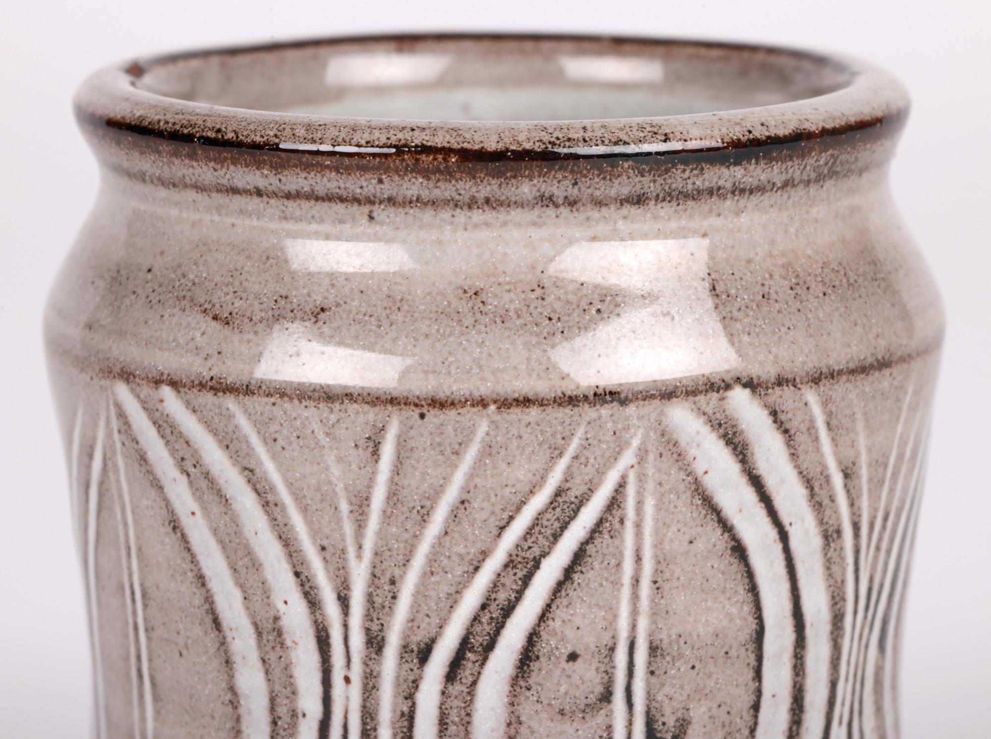 A delightful Lowerdown Pottery stoneware studio pottery albarello shape vase hand decorated with seed pod designs by renowned potter David Leach (British, 1911-2005) dating from around 1970. The hand thrown vase made in terracotta clay stands raised