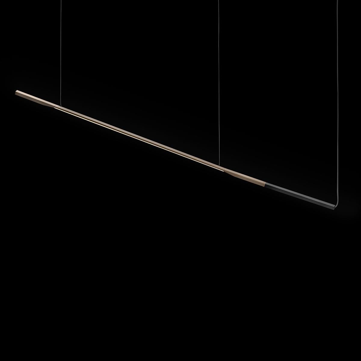 Lampada a sospensione 'Ilo' progettata da David Lopez Quincoces nel 2019.
Lampada a led a sospensione a luce diretta in metallo. Struttura ad asta in alluminio anodizzato in bronzo satinato con terminale anodizzato nero opaco. Prodotto da Oluce,
