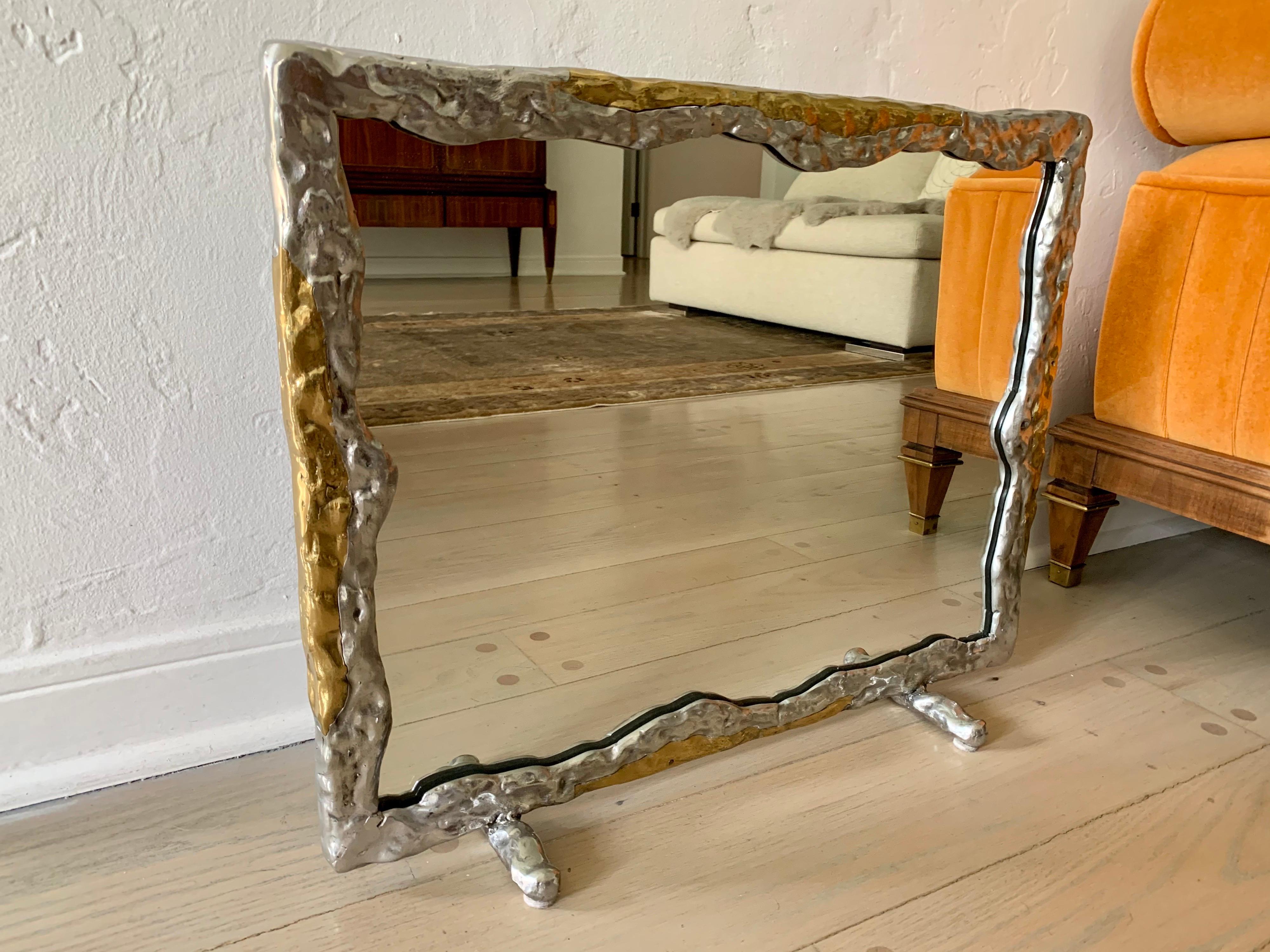 This mixed metal style framed vanity mirror in a brutal design by David Marshall.