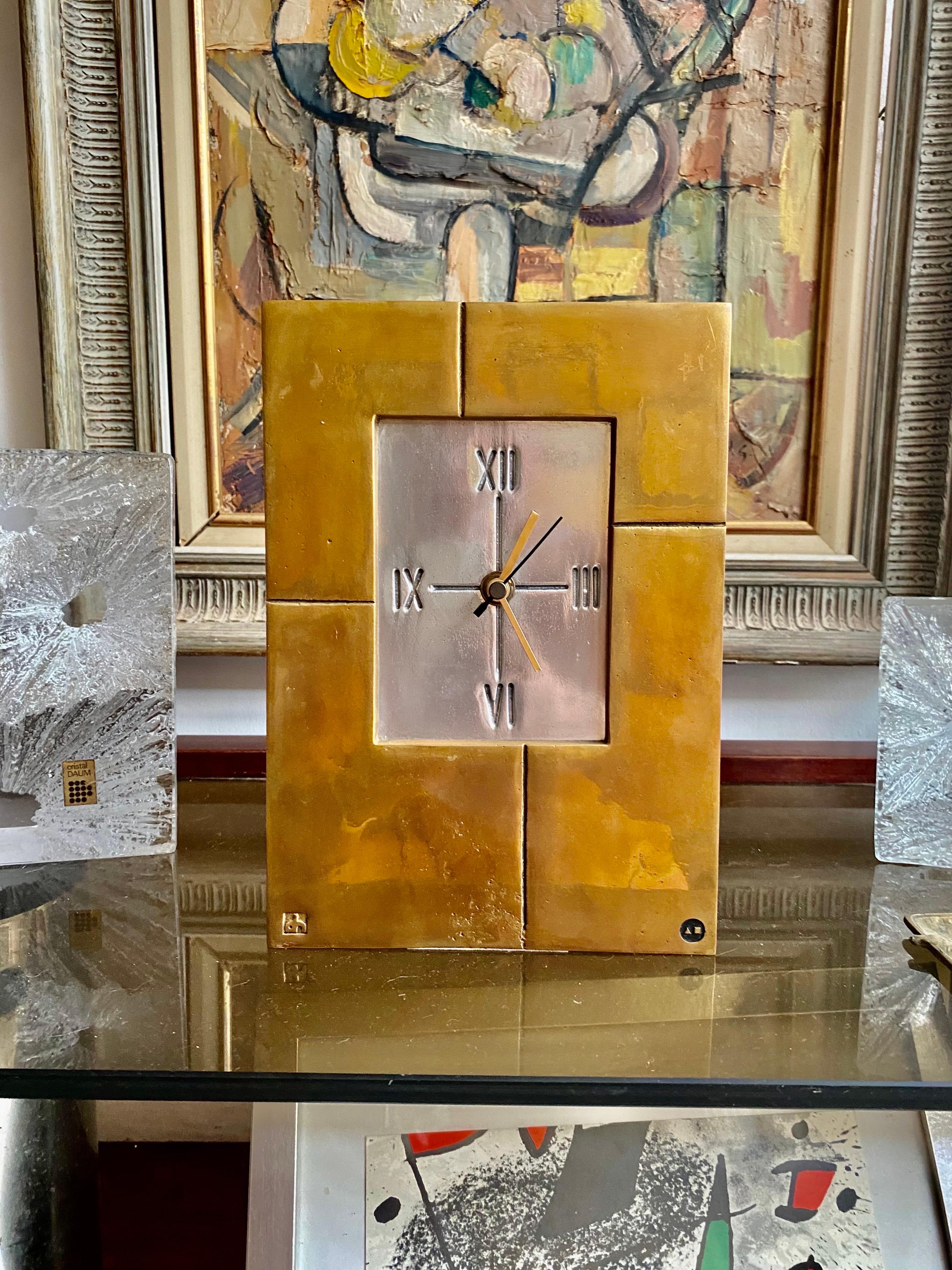 Clock sculpture in bronze and cast aluminum for the base by artist David Marshall.

Marshall moved to Spain in the mid-1960s, opening a workshop in Malaga in 1969 where he produced sculptures, jewelry, silverware and other accessories.
This clock