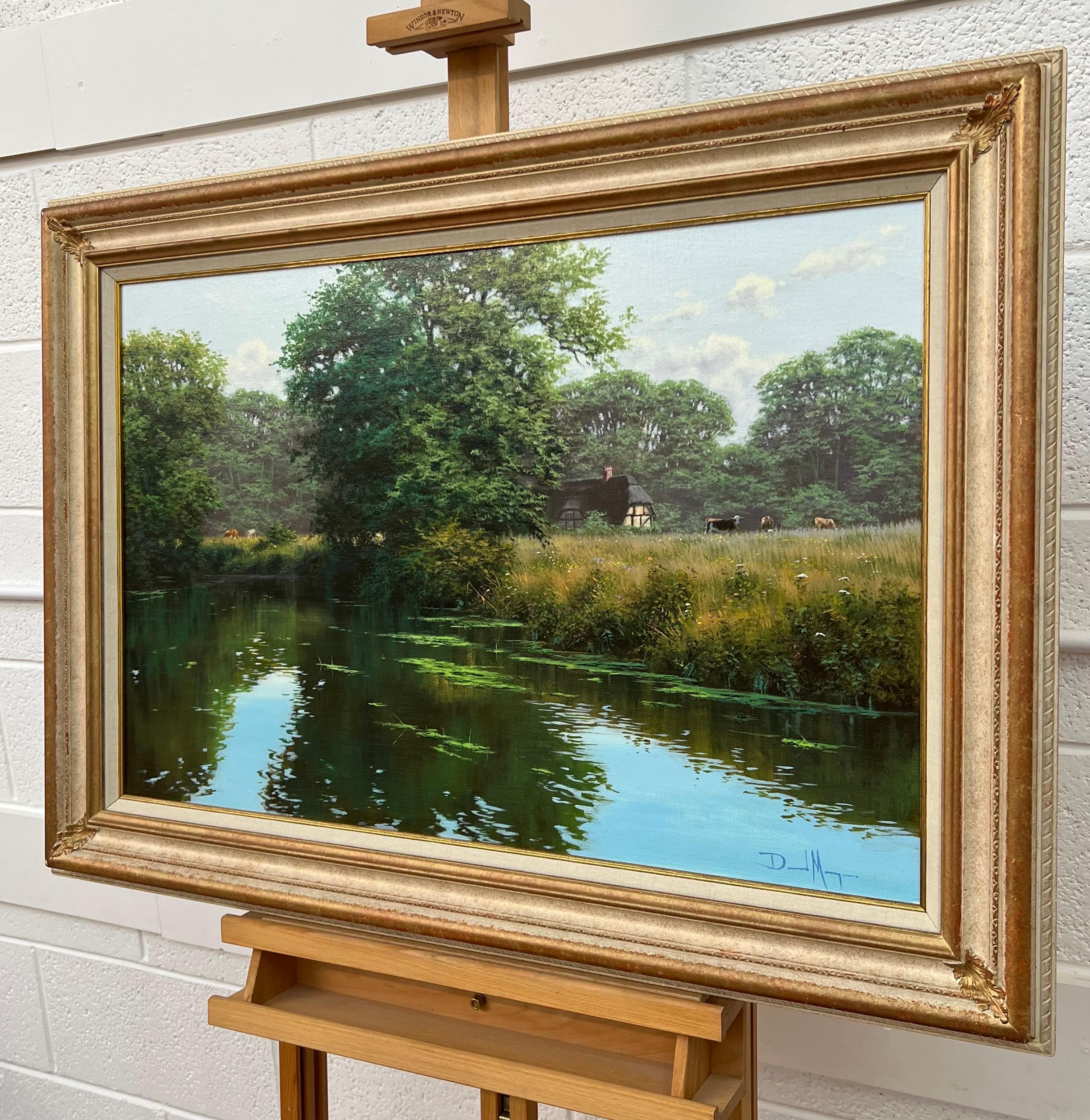 Idyllic Tree-Lined River Landscape Scene with Cattle & Thatched Cottage by British Artist Contemporary Artist, David Morgan (Born 1964). This painting captures the peace and tranquility to be found in the English countryside in summertime, with the