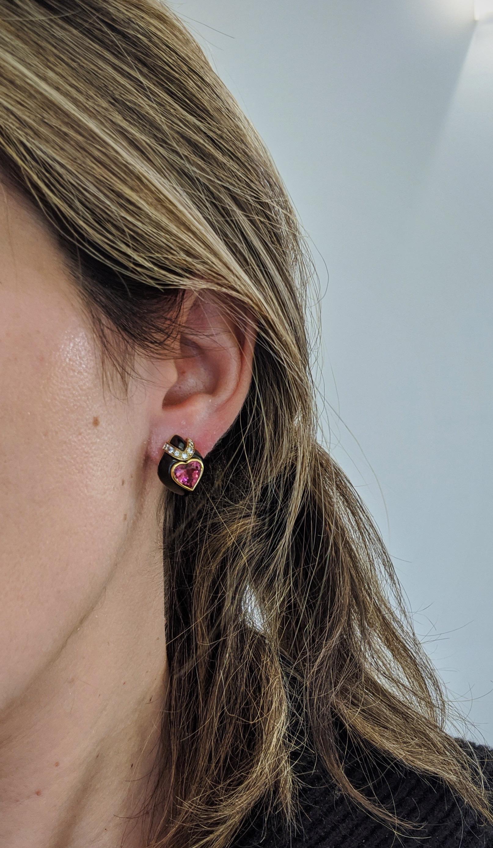 These 18 karat yellow gold teardrop shaped earrings were designed by David Morris.They feature Pink Tourmaline heart centers with a yellow gold bezel setting. The hearts sit on top of an 18 karat blackened gold setting that has been trimmed with