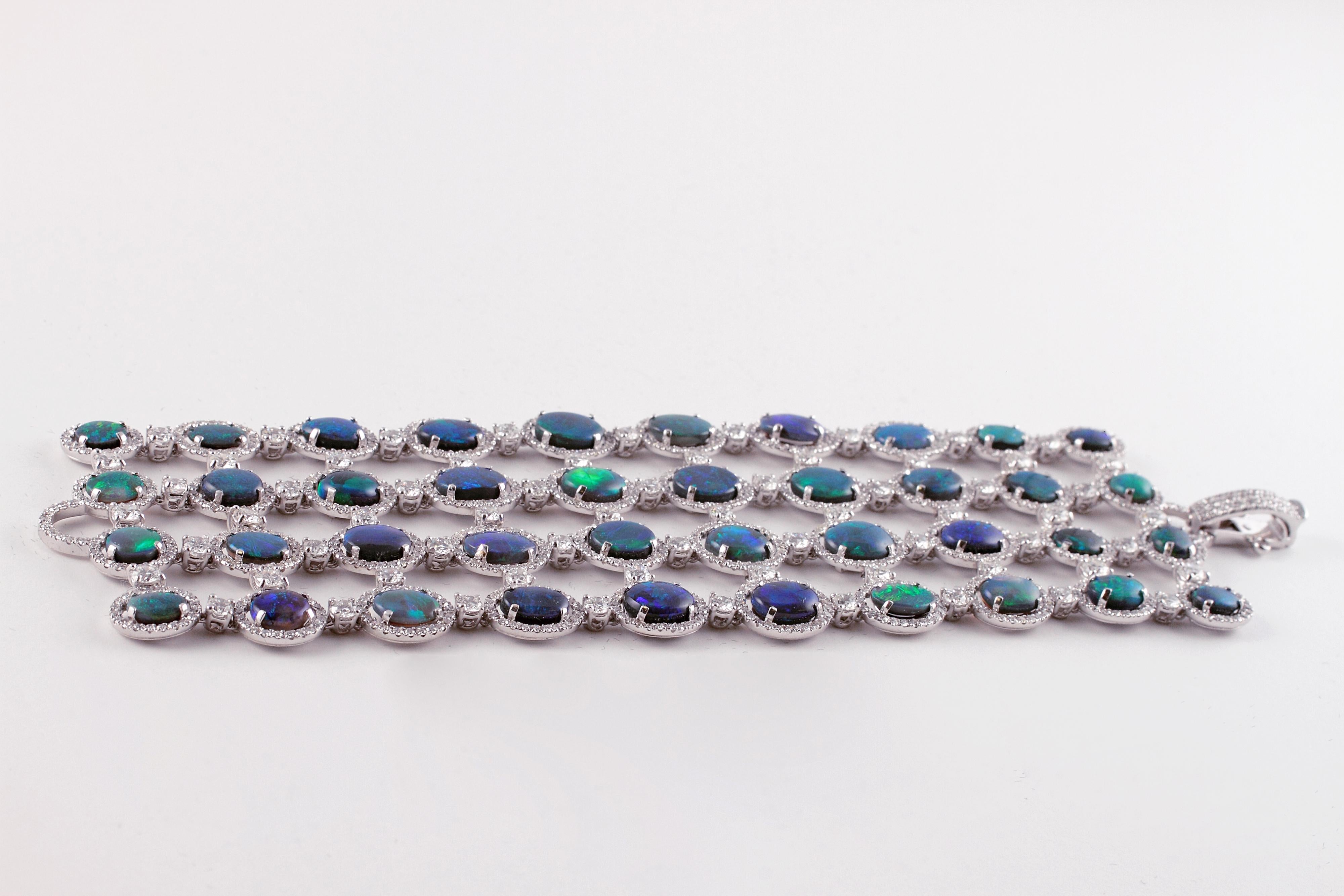 Le jeu de couleurs exquis de ces magnifiques opales est une chose magnifique à contempler !  Ce bracelet a été fabriqué à la main à Londres par le célèbre créateur de bijoux David Morris.  Il présente 4 rangées d'opales de tailles et de couleurs
