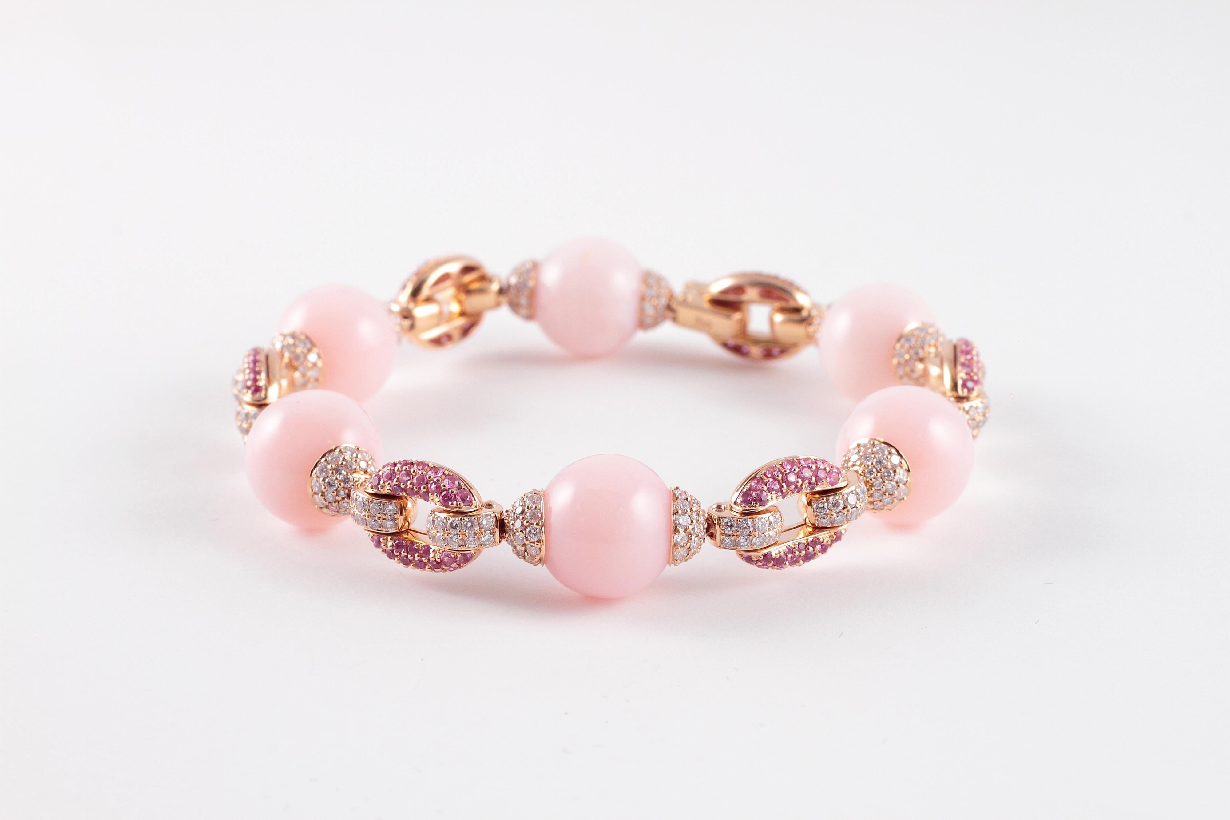 Purchased from famed jewelry designer David Morris of London, this lovely bracelet is in warm and inviting 18 karat rose gold and the pink color in the six beautifully matched opals is complimented by the bright sparkle of the 2.14 carats of pink