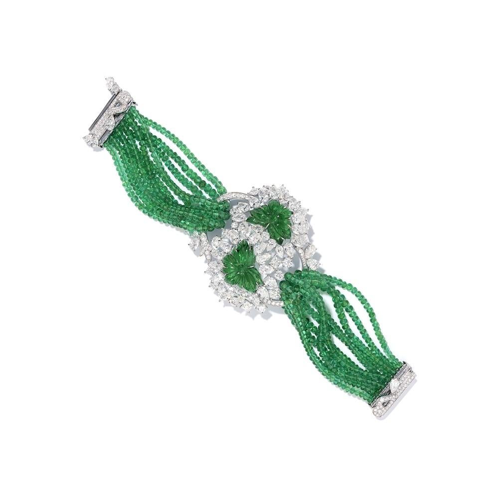 This magnificent carved emerald and white diamond bracelet from David Morris brings together a remarkable collection of the world’s most vibrant and desirable emeralds. At the bracelet’s centerpiece are two large emeralds, hand-carved with leaves