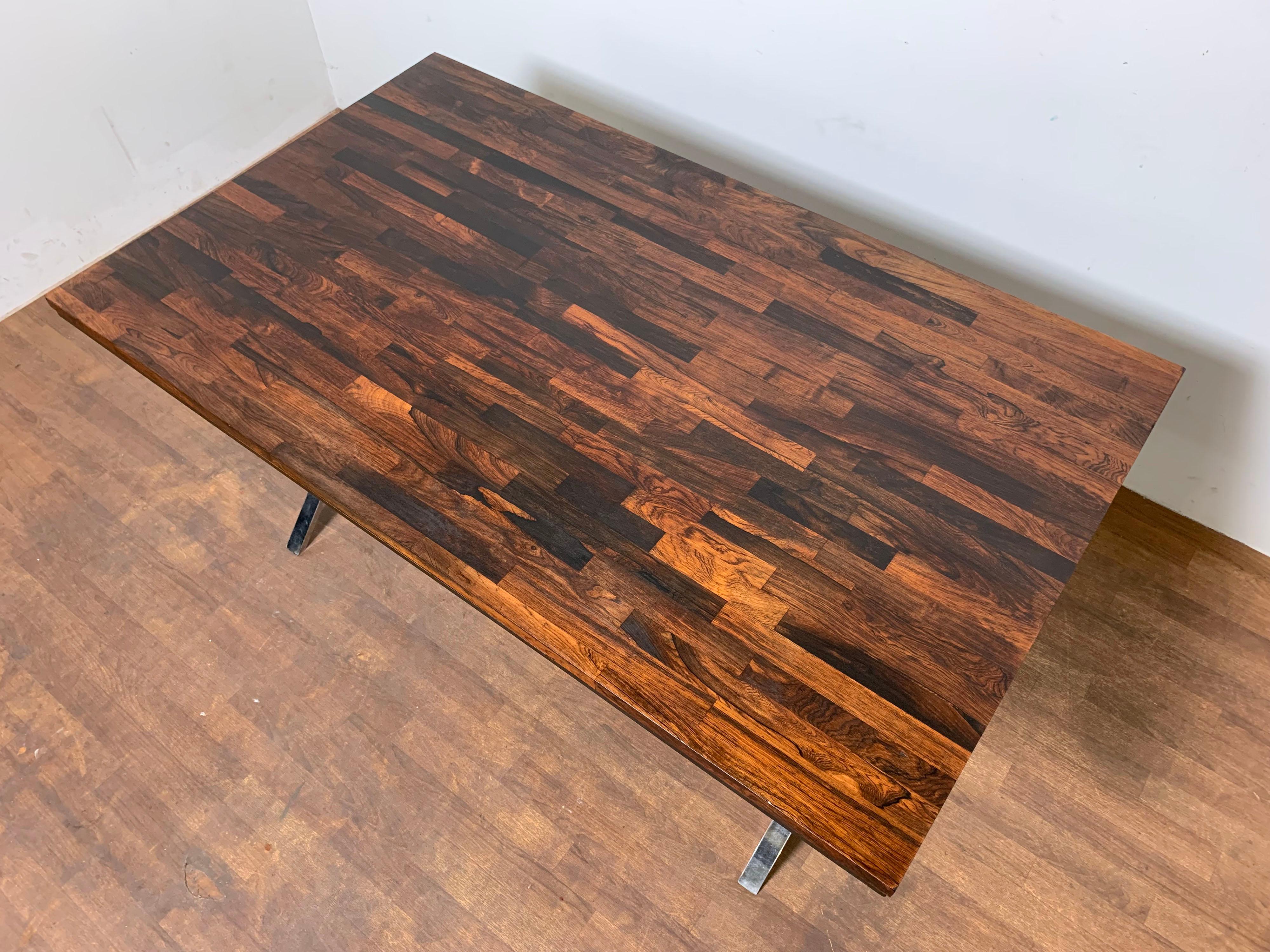 Mid-century modern writing desk featuring a staved rosewood top over an X-form chrome base, designed by Dave Parmelee for Founders Furniture, circa 1970s.