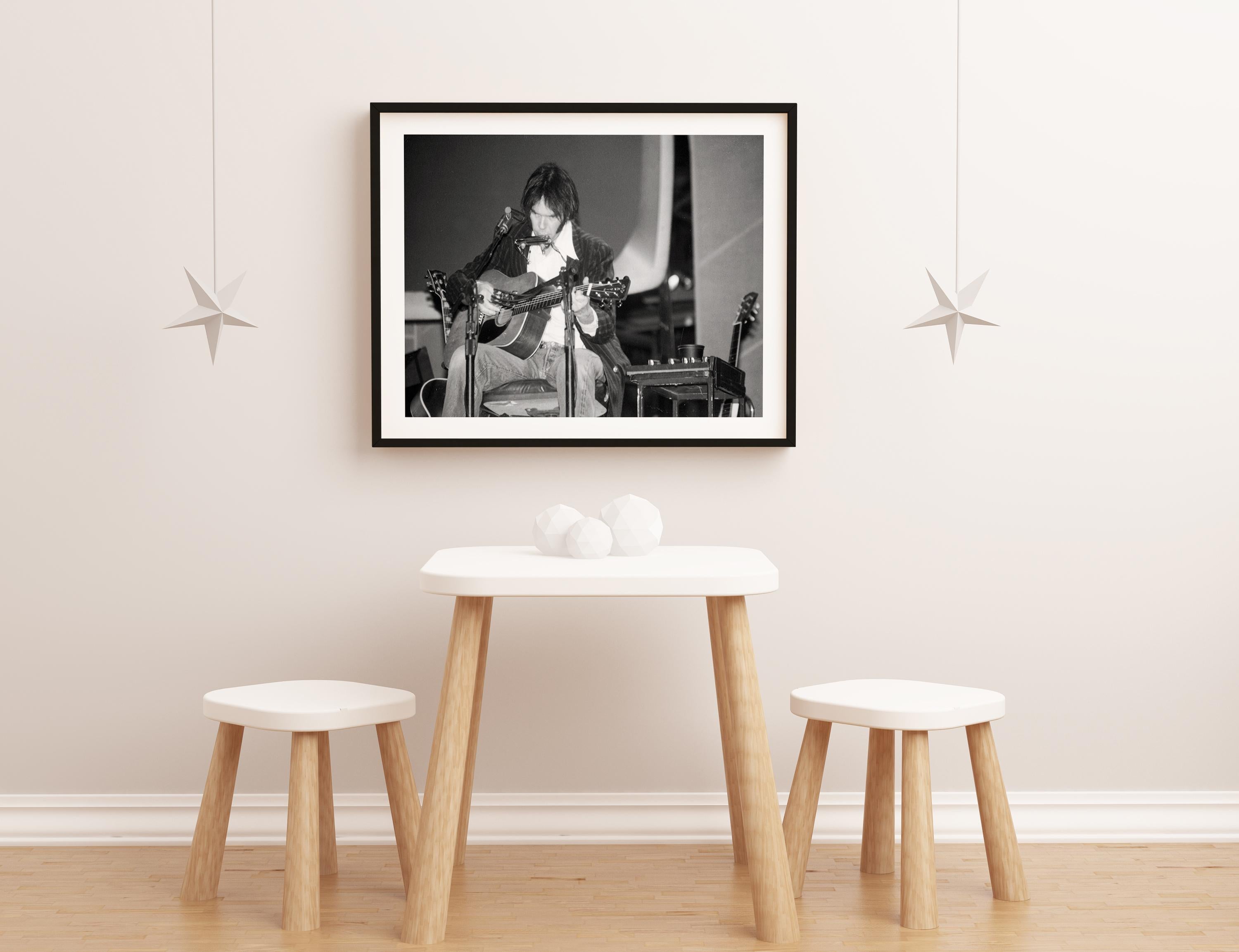Neil Young Playing Guitar and Harmonica on Stage Fine Art Print - Black Portrait Photograph by David Plastik