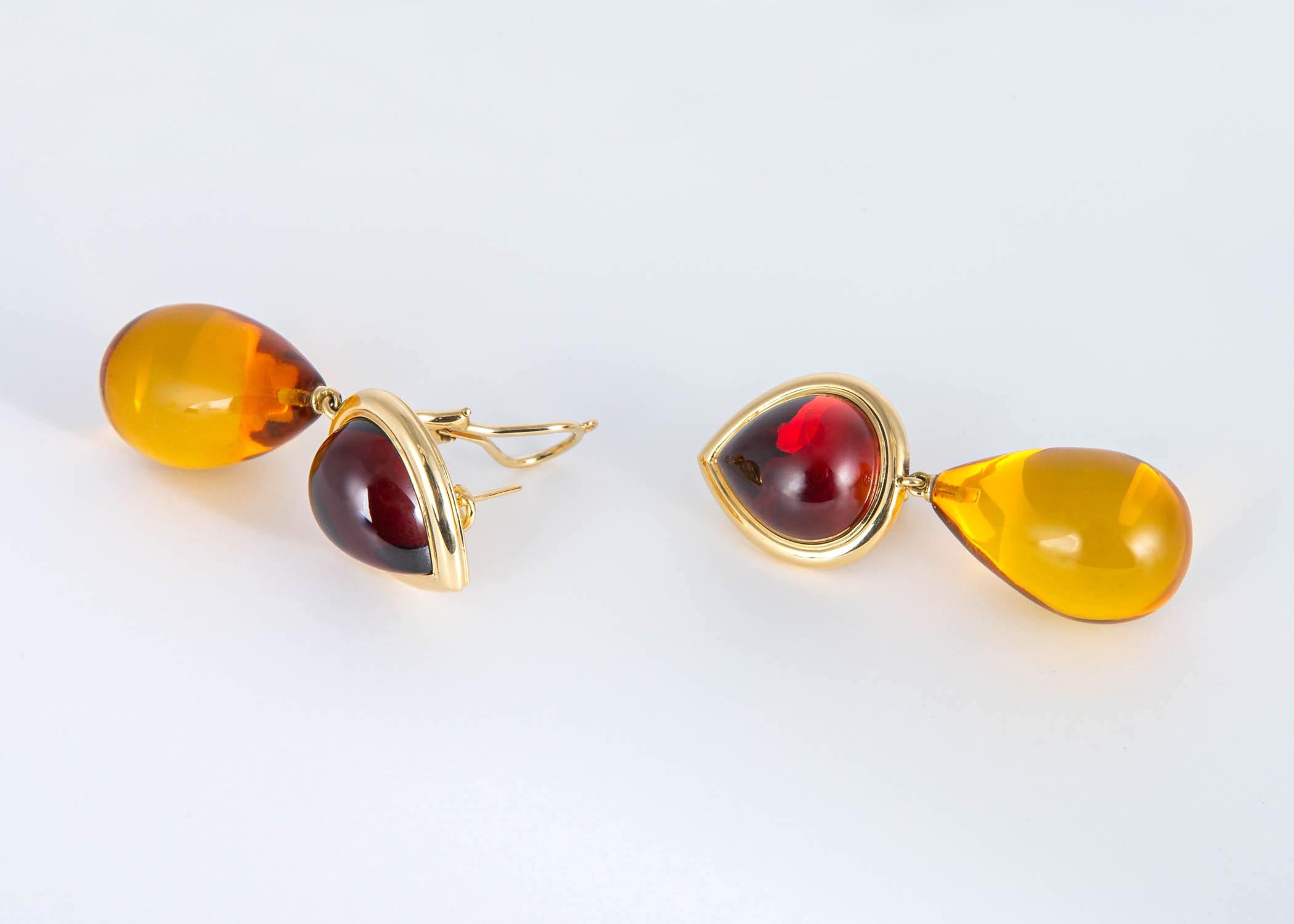 Completely handmade and unique. Featuring a pair of cabochon garnets that simply glow from with in and a rich pair of amber drops. A  true statement piece. 2 1/8 inches in length.